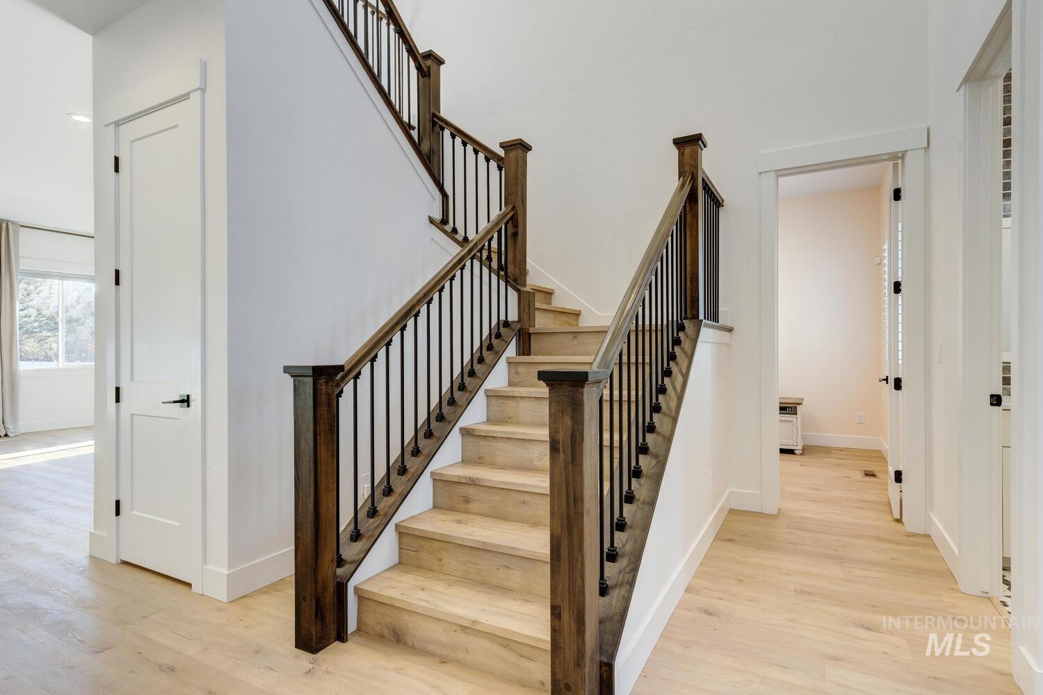 Stairs with wood finished floors and baseboards