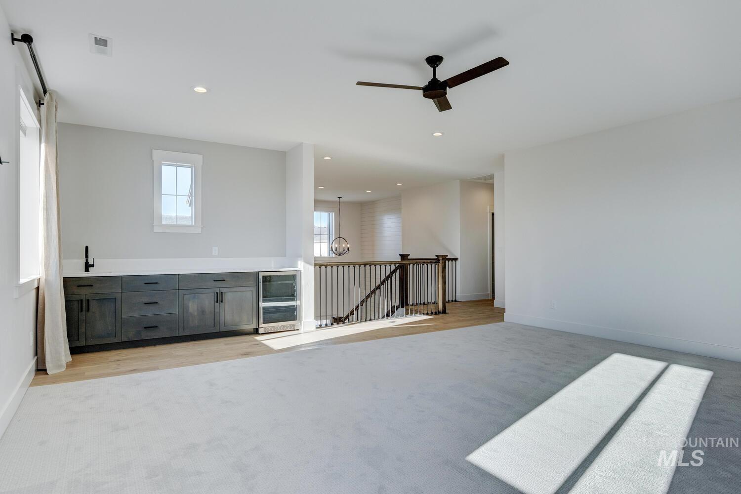 Bar area featuring light countertops, light colored carpet, recessed lighting, and a ceiling fan