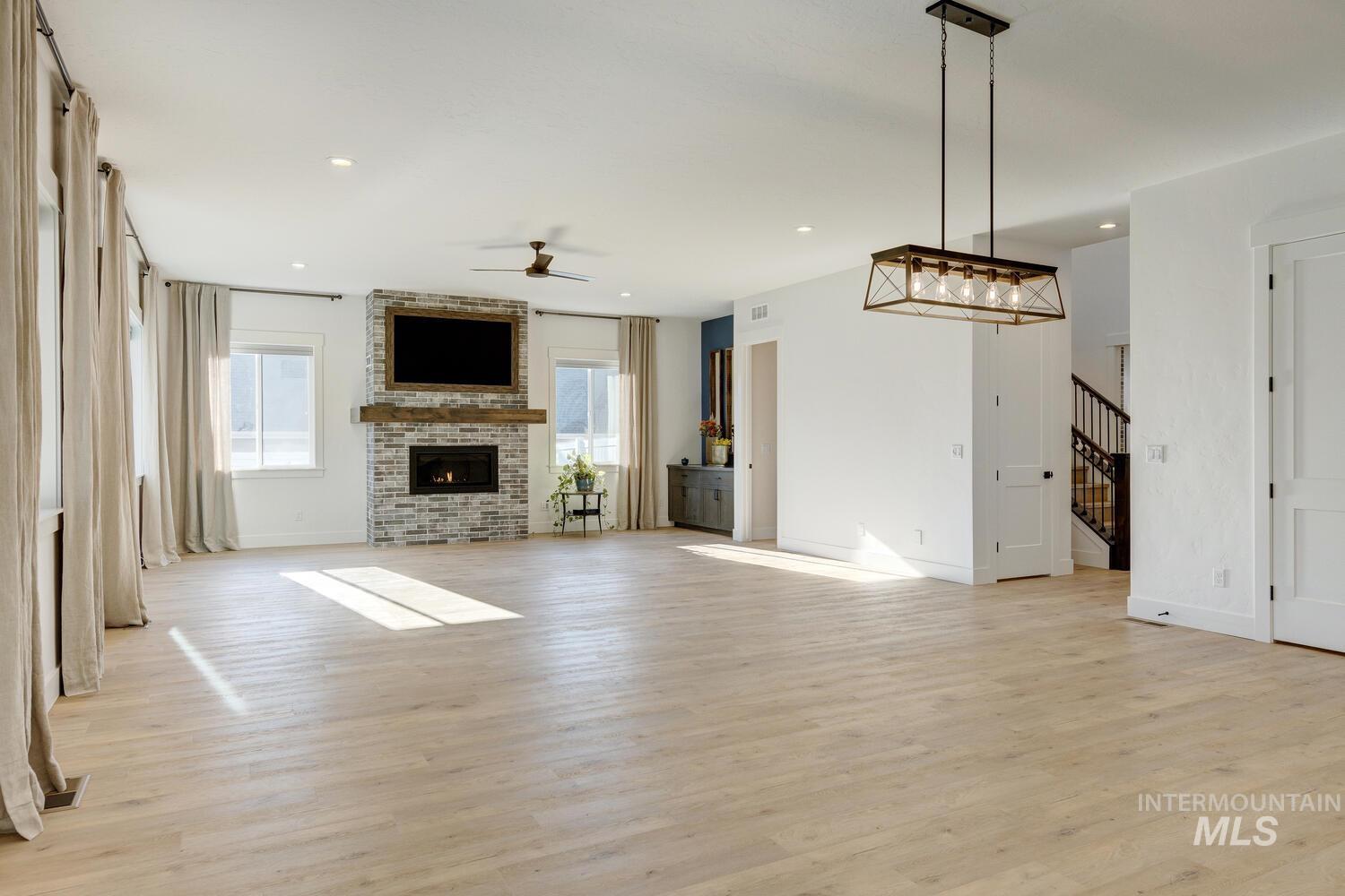 Unfurnished living room featuring light wood-type flooring, a fireplace, healthy amount of natural light, and recessed lighting