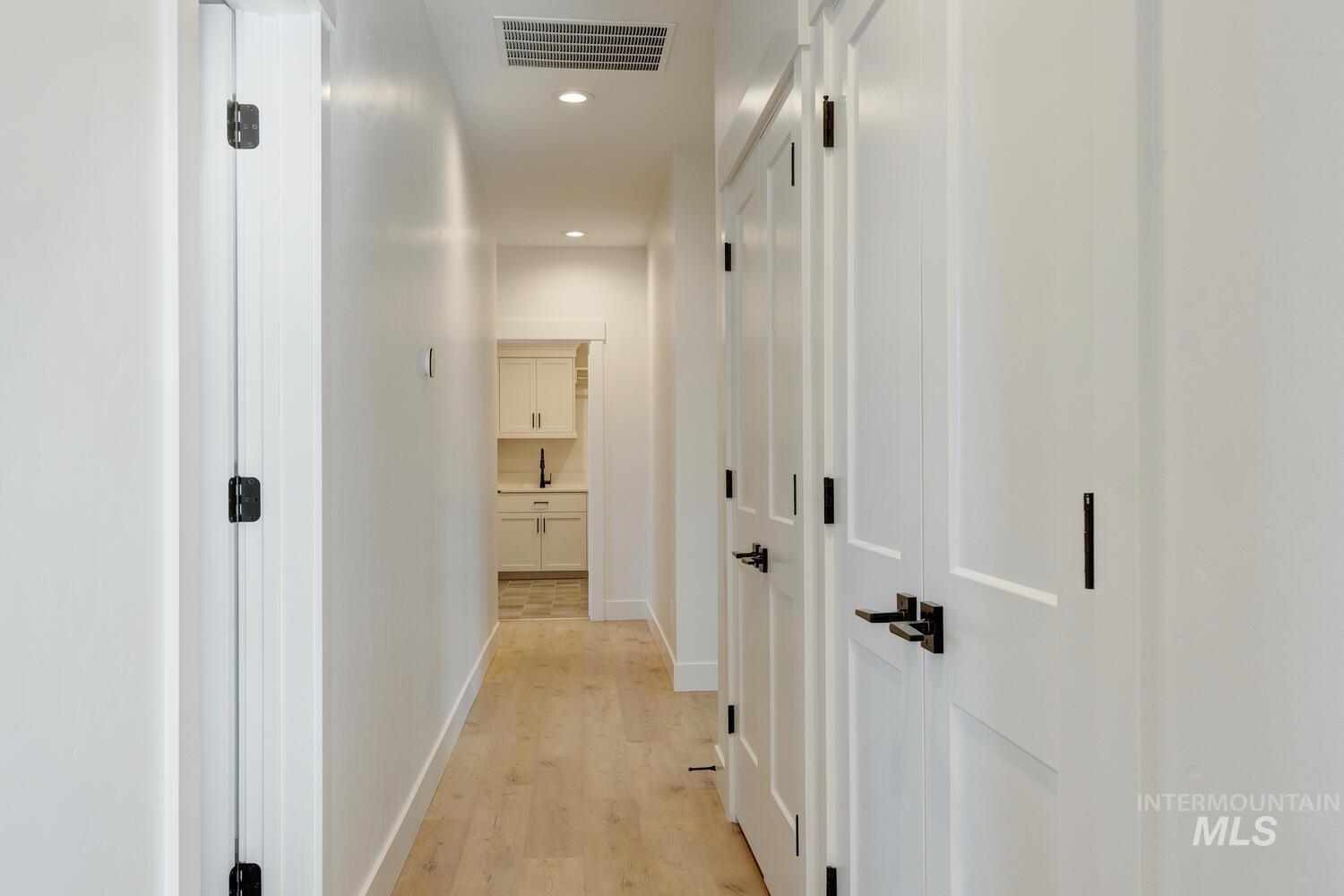 Hall featuring light wood finished floors and recessed lighting