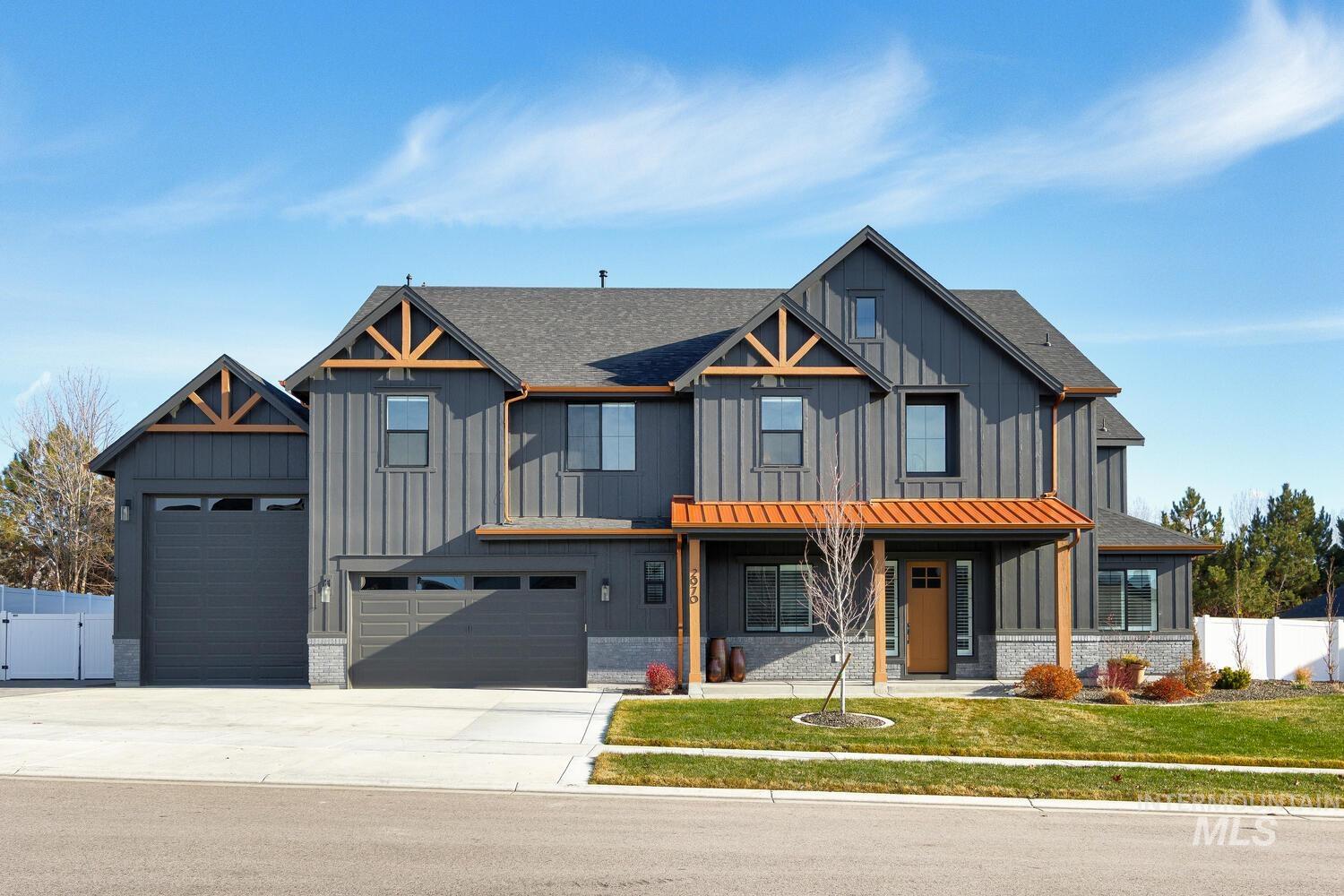 Modern farmhouse with board and batten siding, covered porch, concrete driveway, and a shingled roof