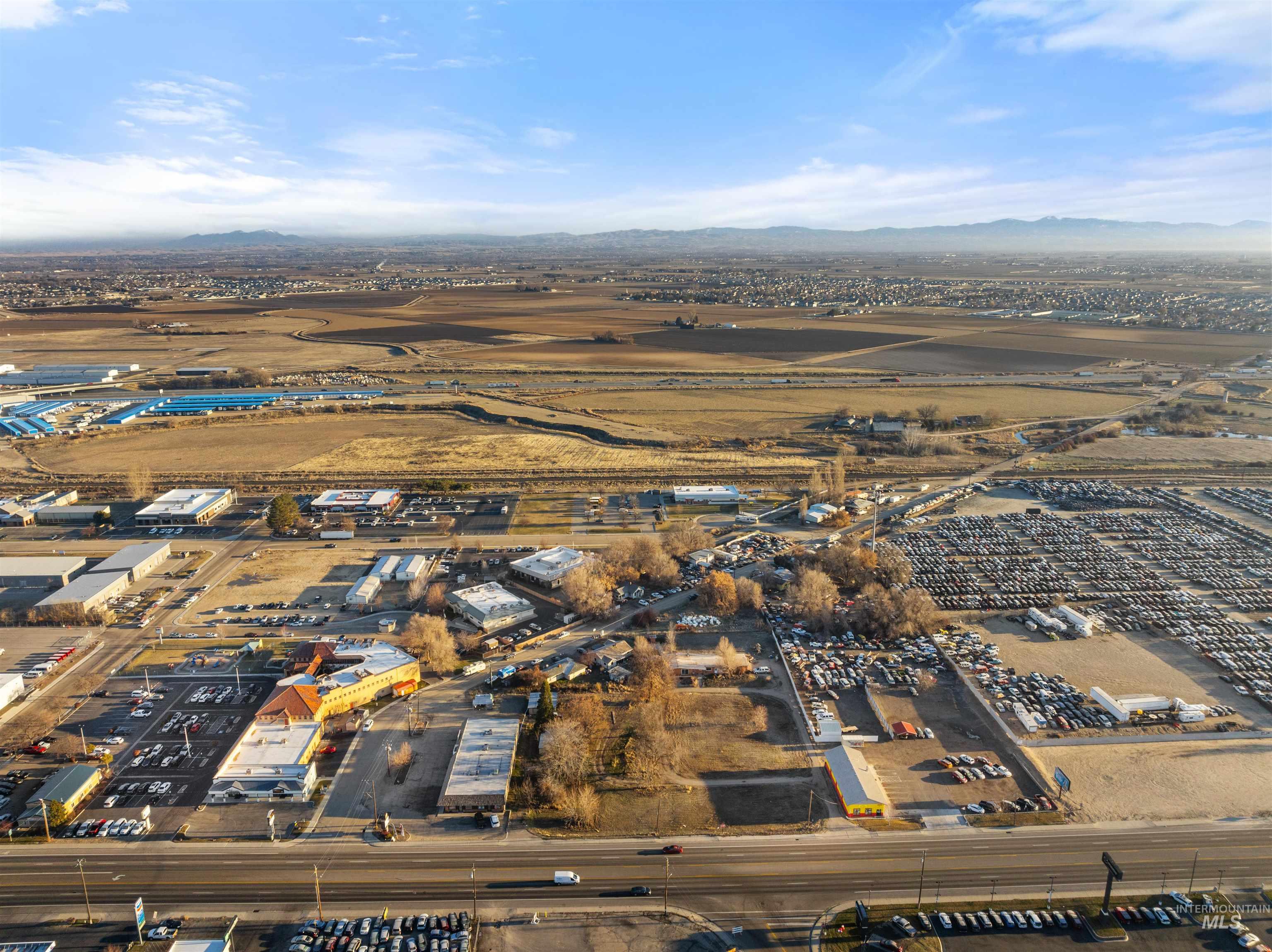 Aerial view of property and surrounding area featuring an industrial area and mountains