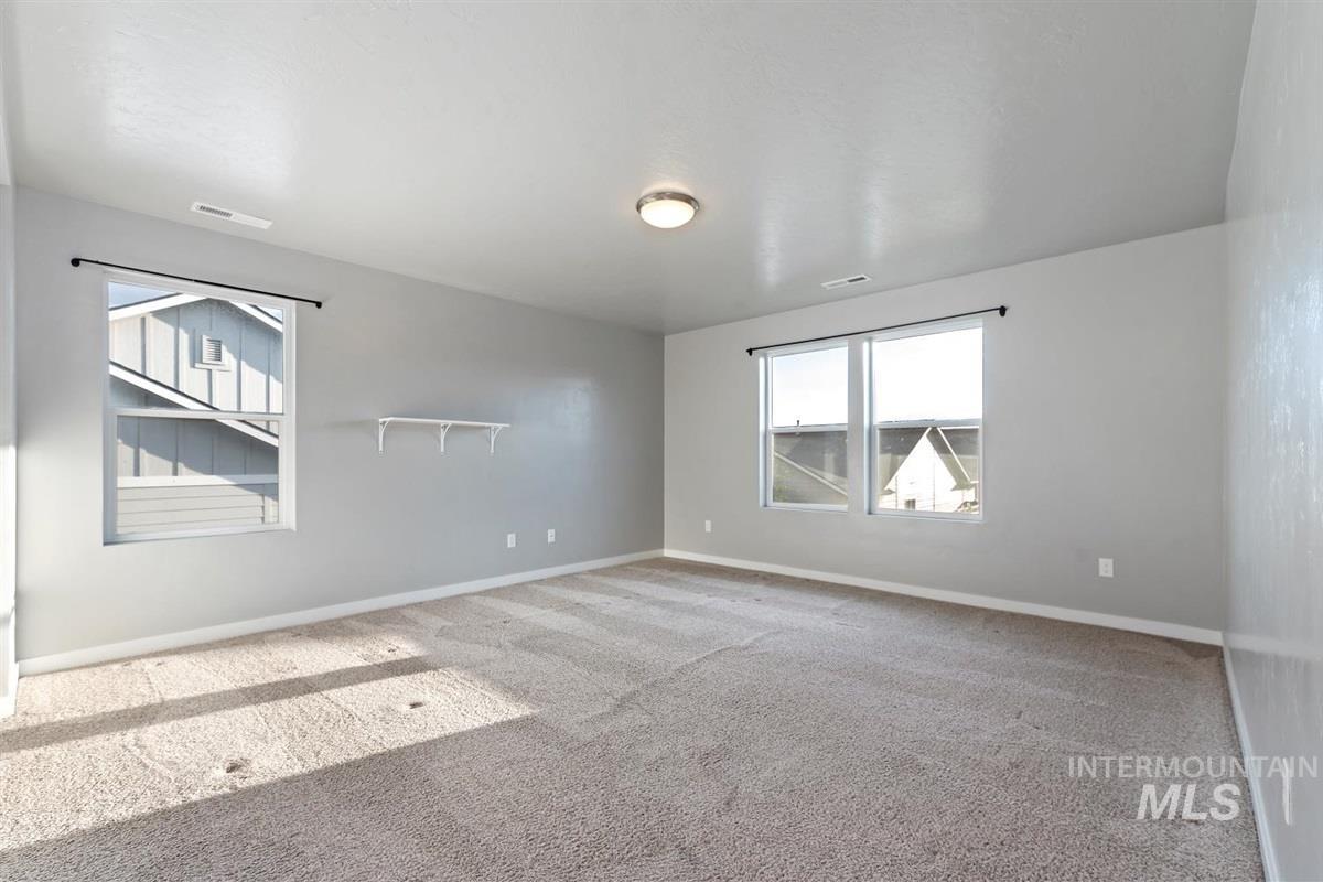 Carpeted empty room featuring baseboards