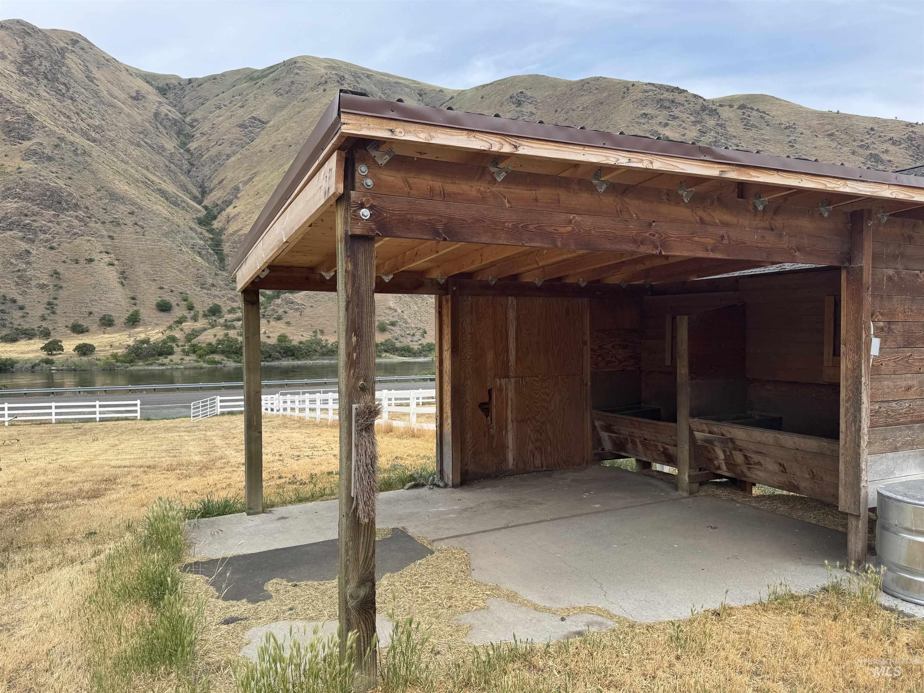 View of parking with a water and mountain view and an exterior structure