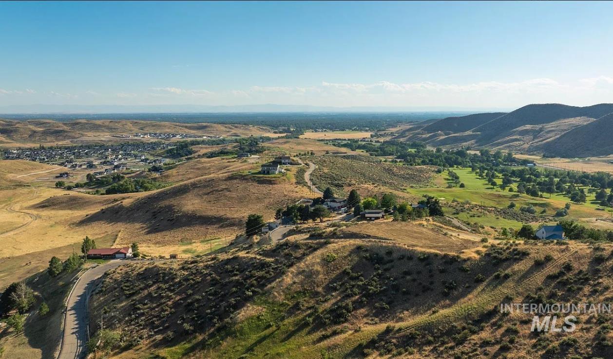 Aerial view of property's location with rural landscape and a mountain backdrop