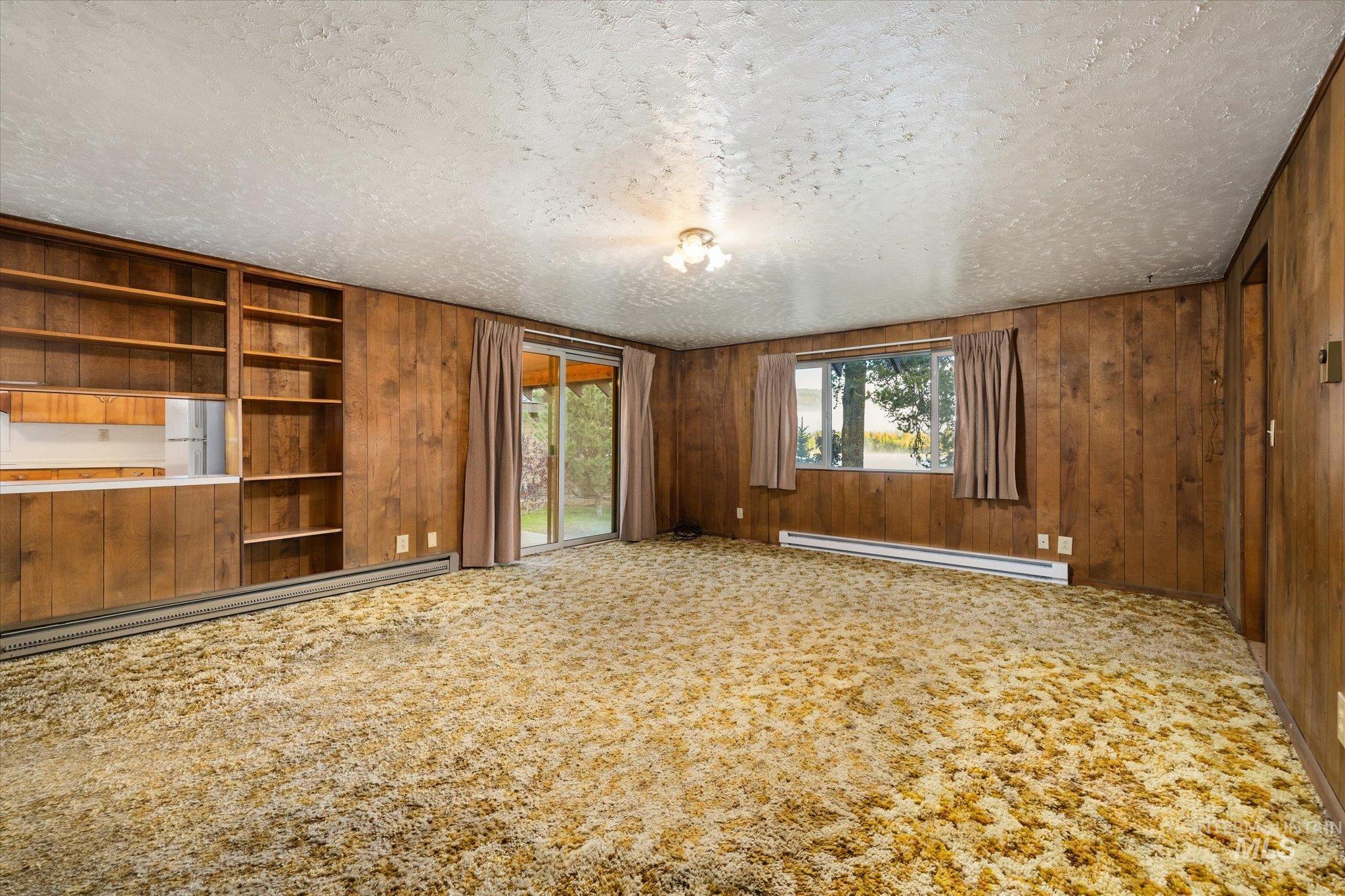Interior space featuring wood-paneled walls and a textured ceiling