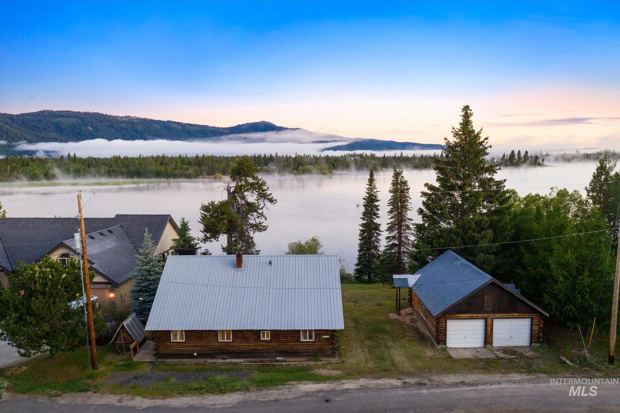 Wood-sided residence with a metal roof and an accompanying two-car garage