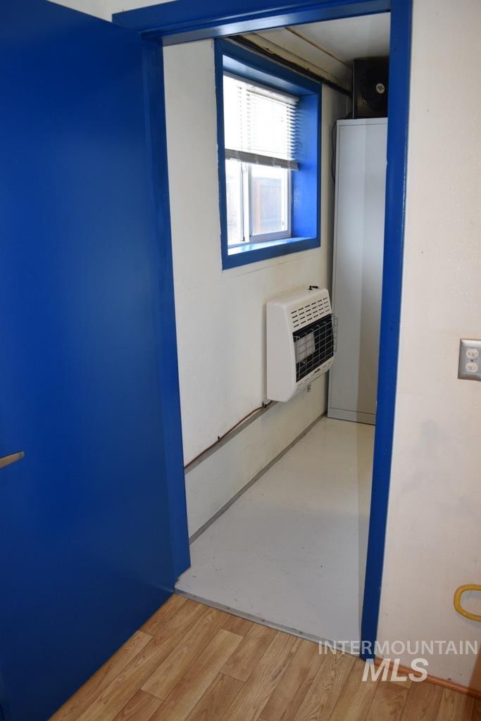 Hallway featuring light wood-type flooring and heating unit