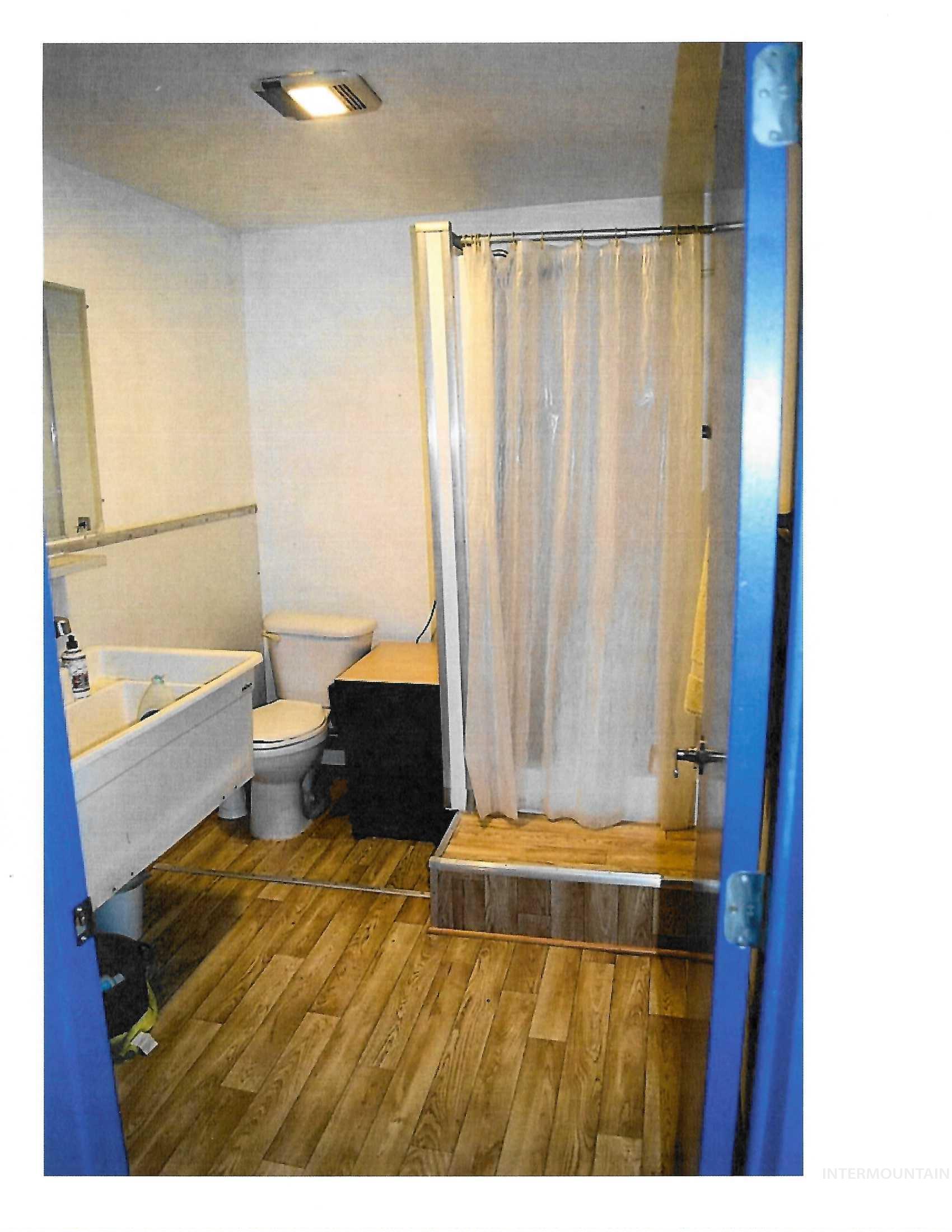 Bathroom featuring hardwood / wood-style floors and a stall shower