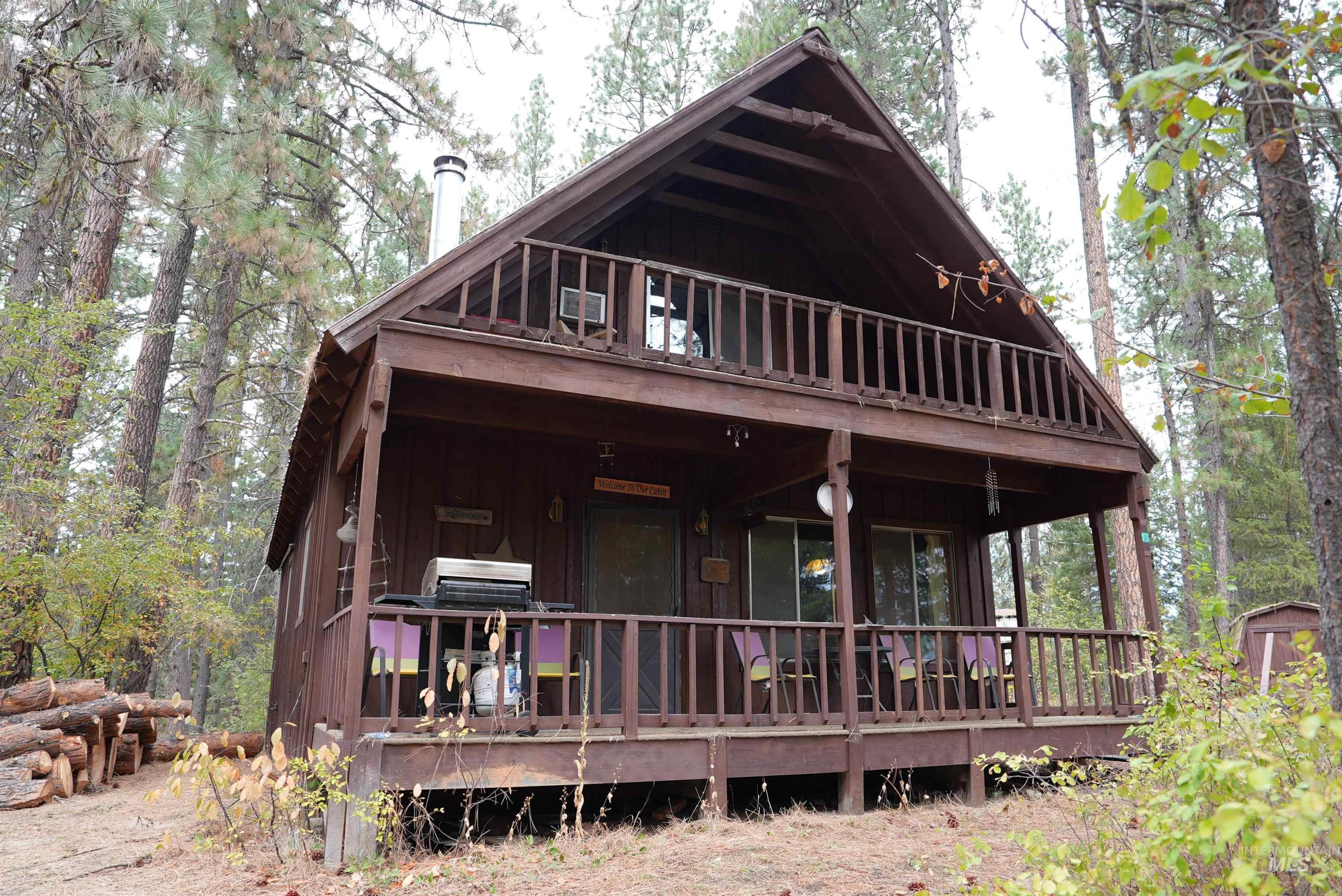 View of front of home featuring board and batten siding, an outbuilding, and a wooden deck