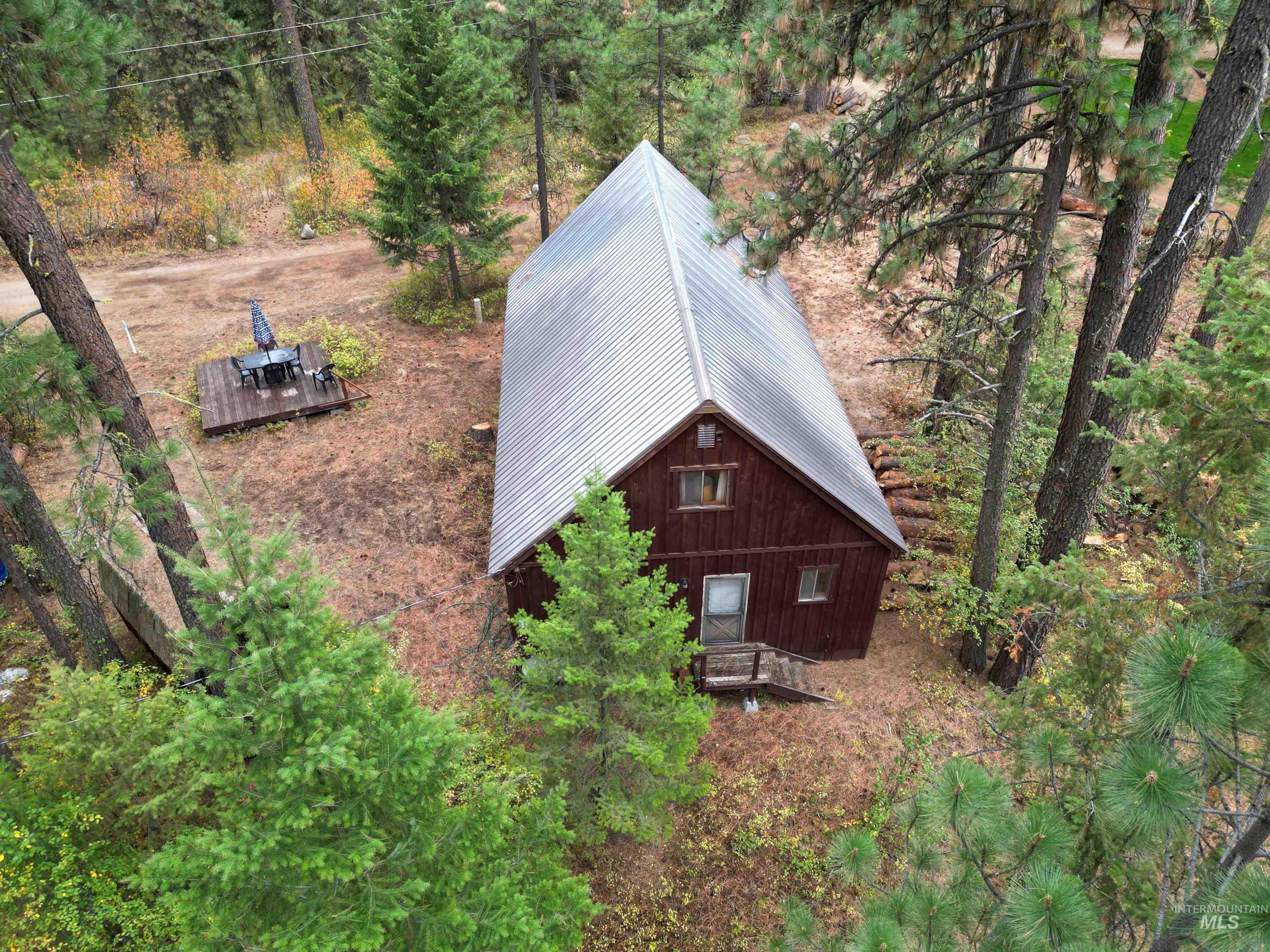 View of property exterior with a metal roof and a wooded view