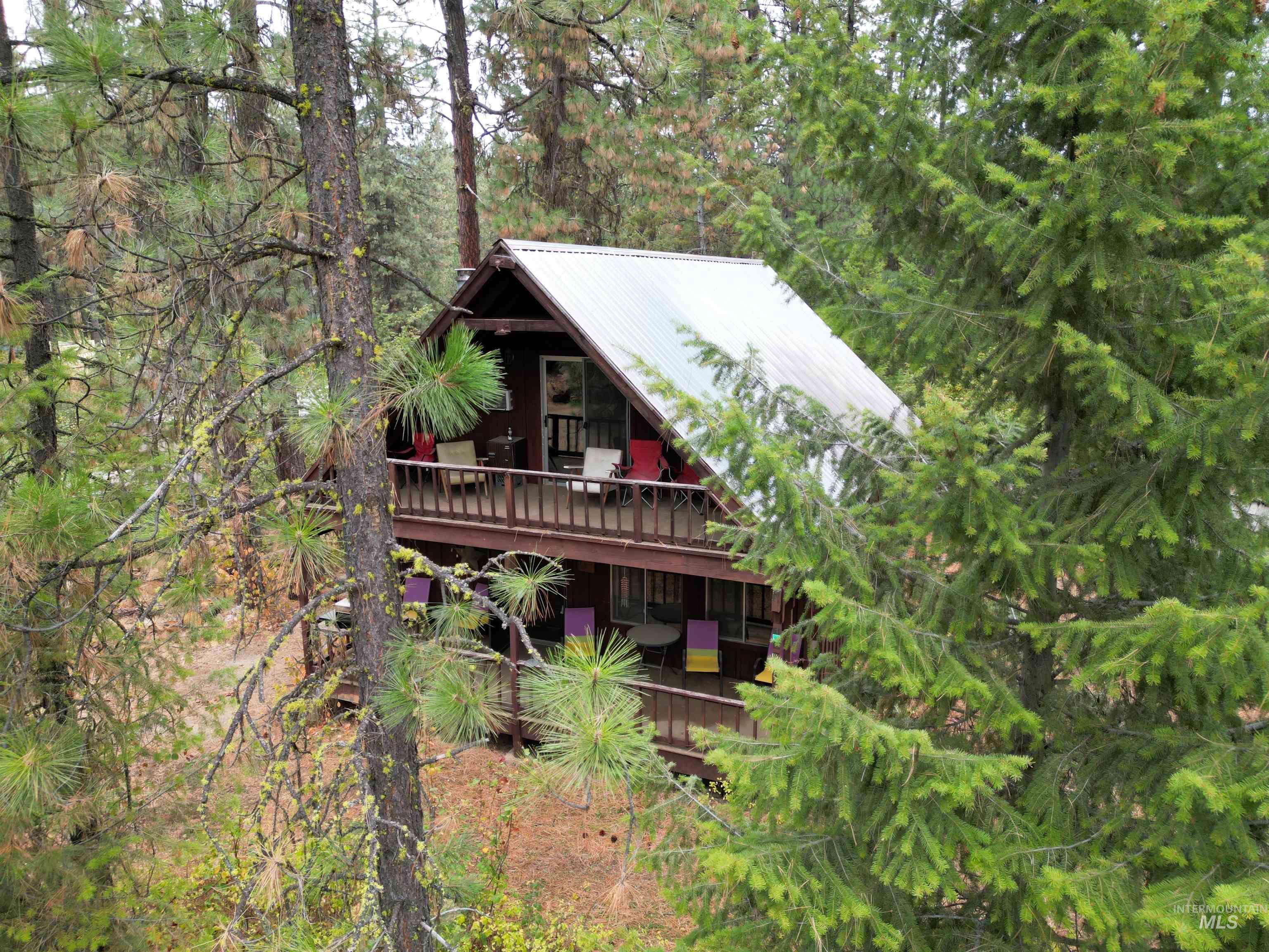Rear view of house featuring a metal roof and a balcony