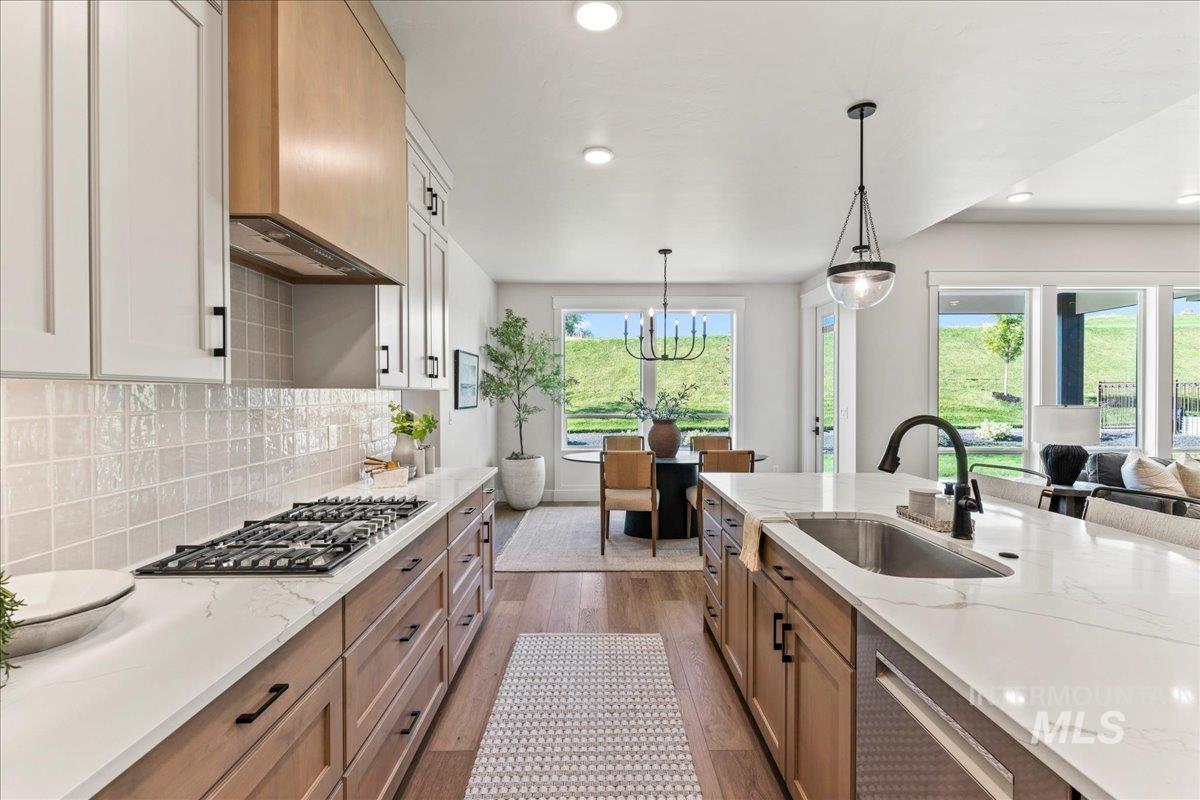 Kitchen with light stone countertops, dark wood-style floors, pendant lighting, brown cabinetry, and recessed lighting