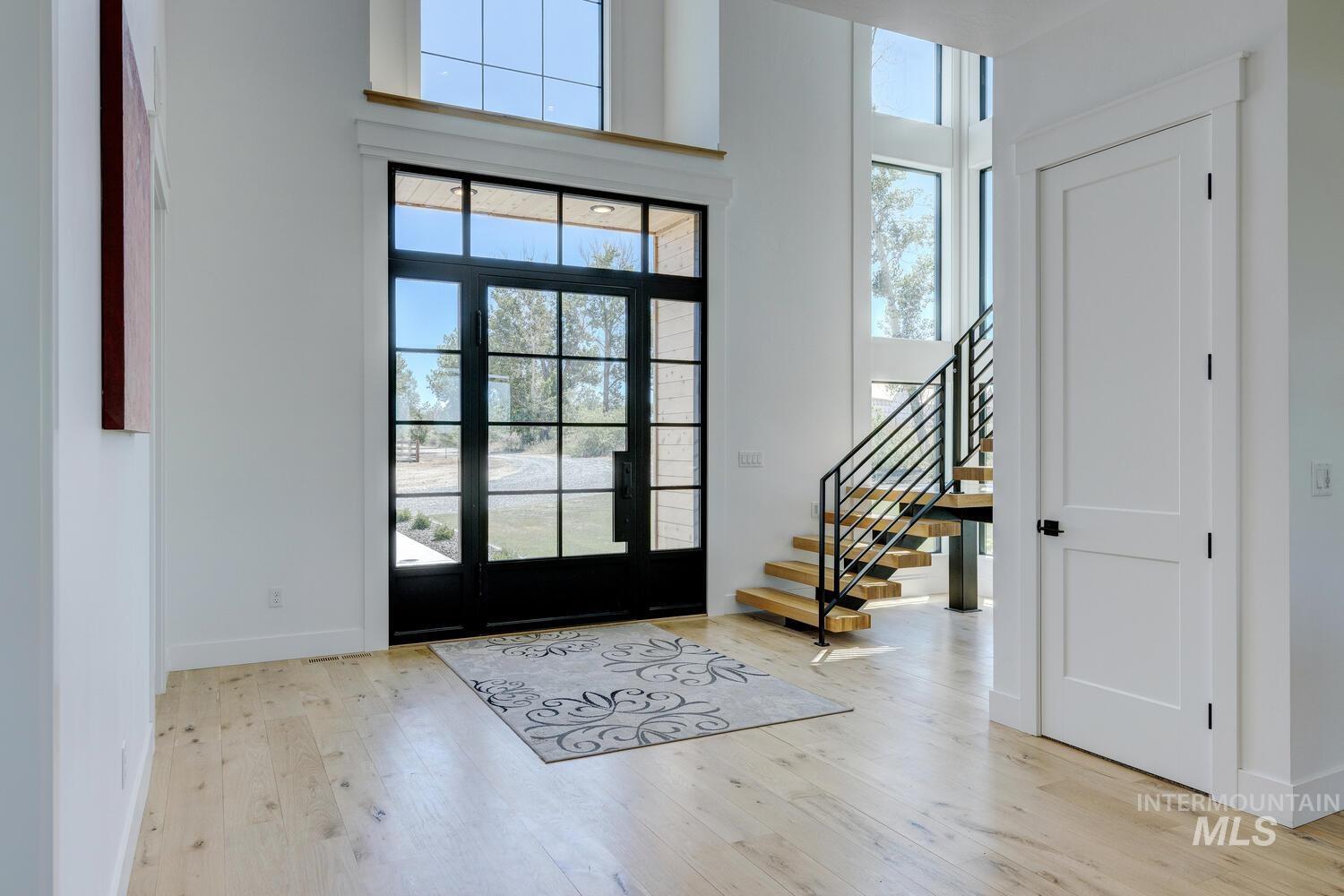Entryway featuring healthy amount of natural light, wood finished floors, and stairs