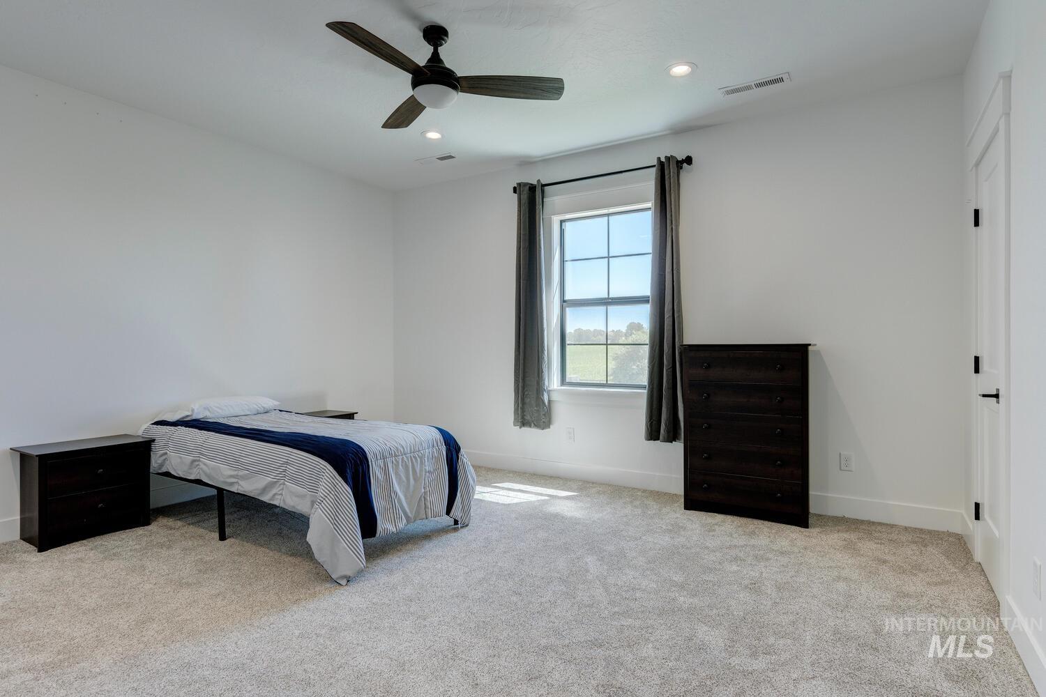 Carpeted bedroom featuring recessed lighting and a ceiling fan