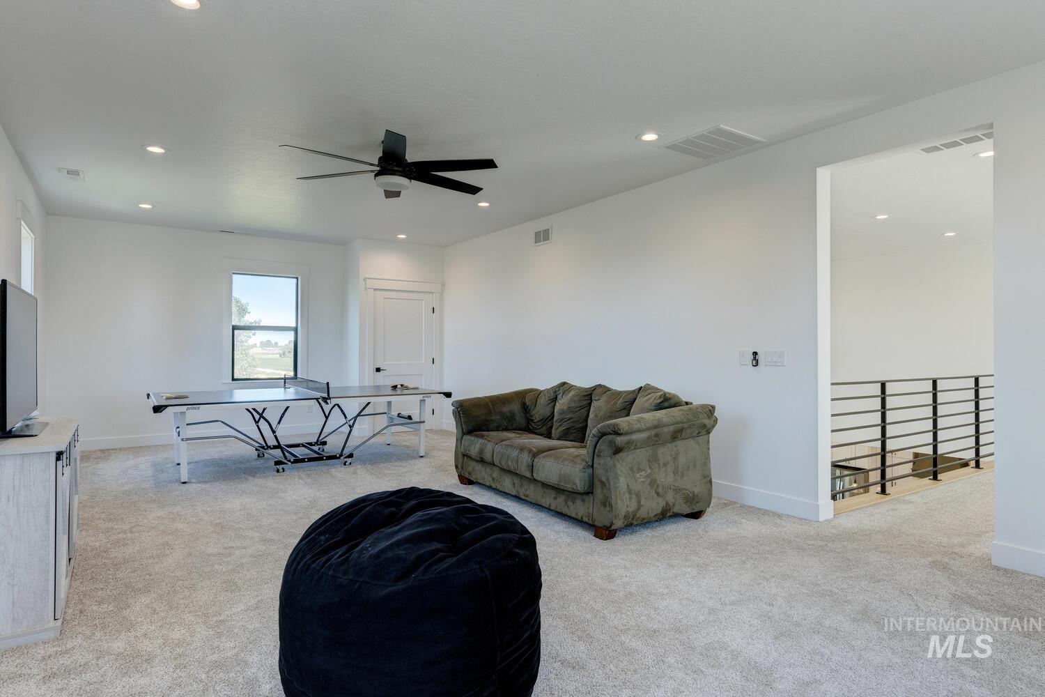 Living room with light carpet, a ceiling fan, and recessed lighting
