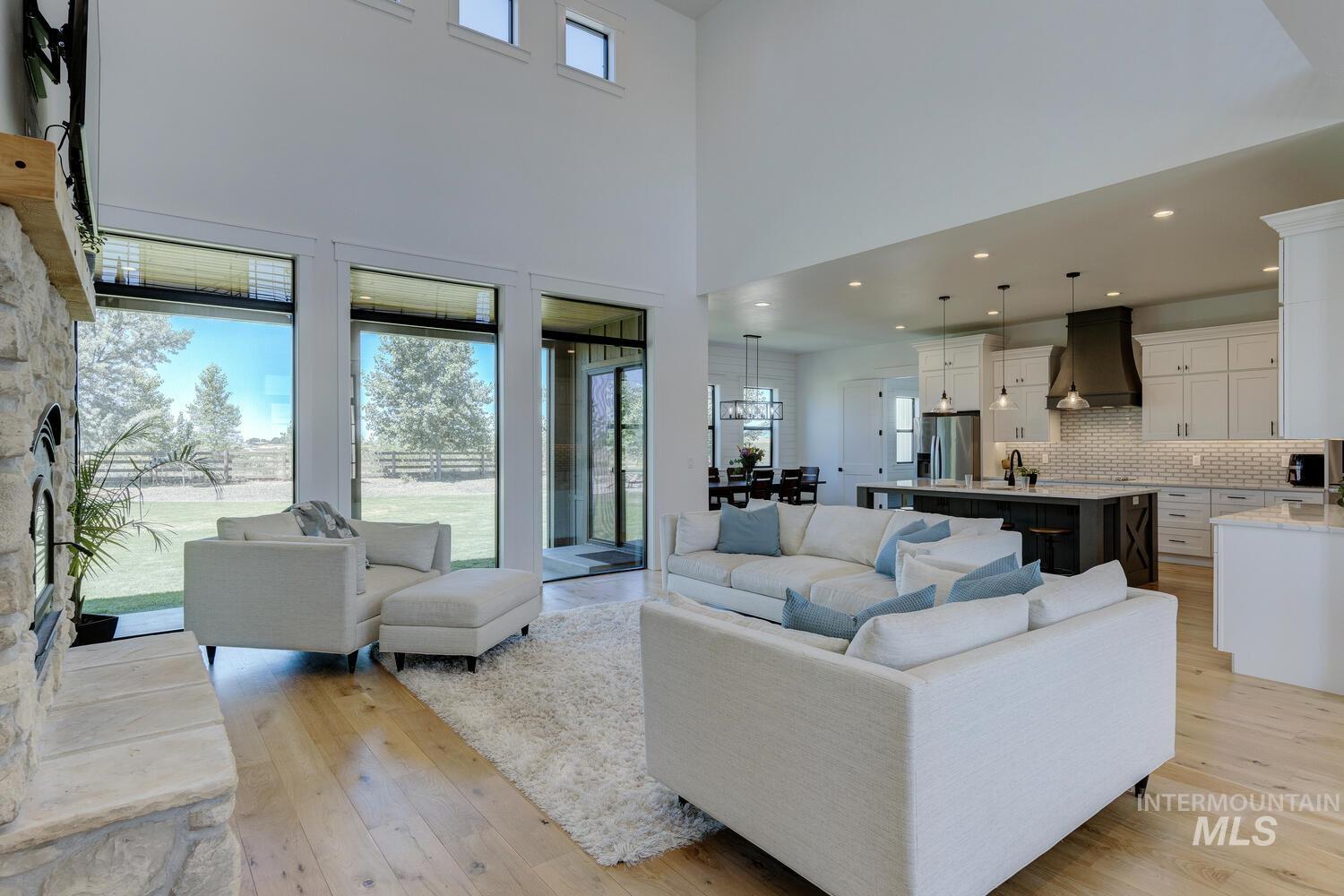 Living room featuring light wood-style flooring, a high ceiling, and recessed lighting