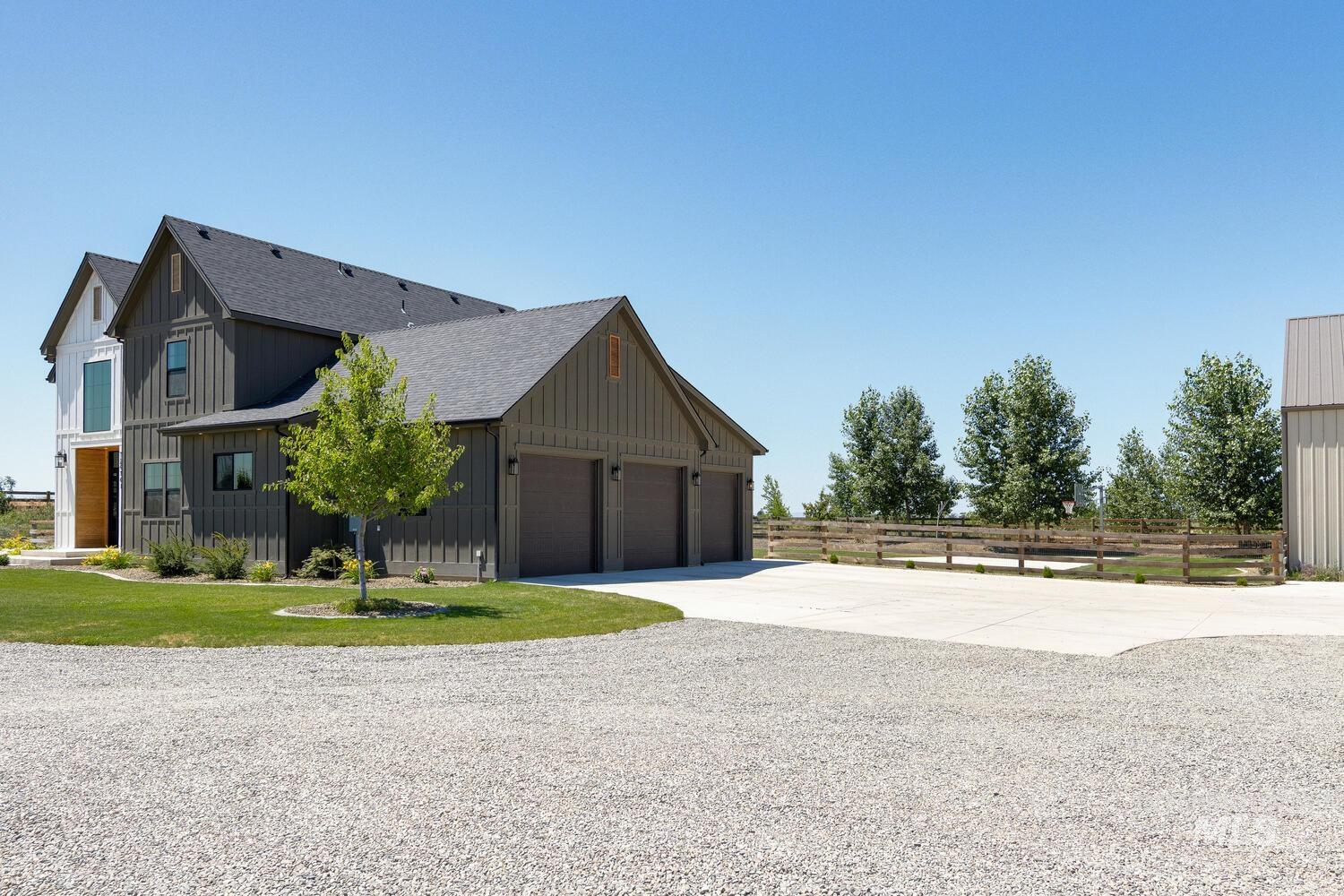 View of side of home featuring board and batten siding, roof with shingles, and concrete driveway