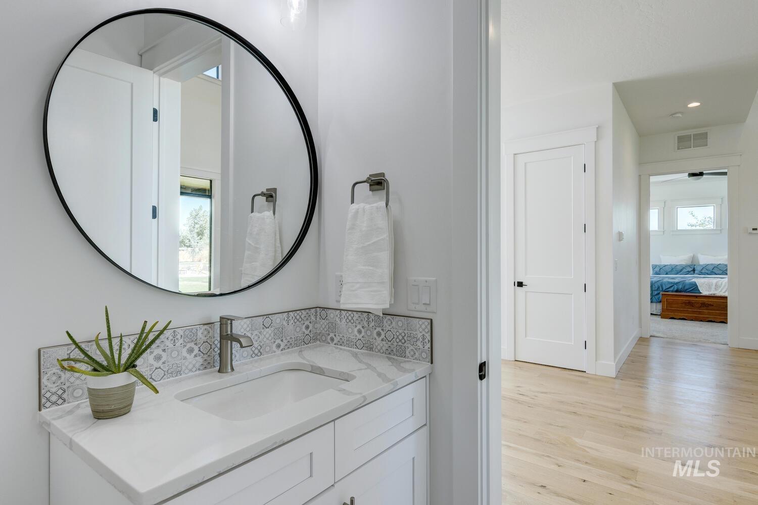 Ensuite bathroom featuring vanity, wood finished floors, and recessed lighting