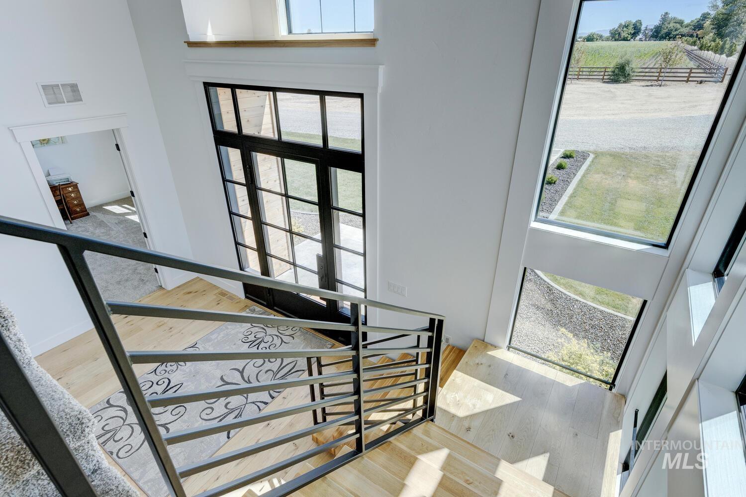 Stairway featuring wood finished floors and a high ceiling