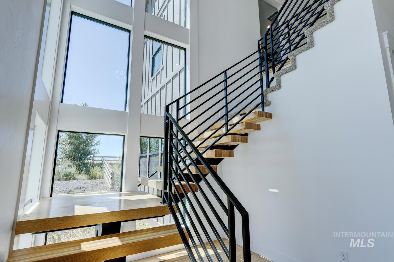Stairway with a towering ceiling and baseboards