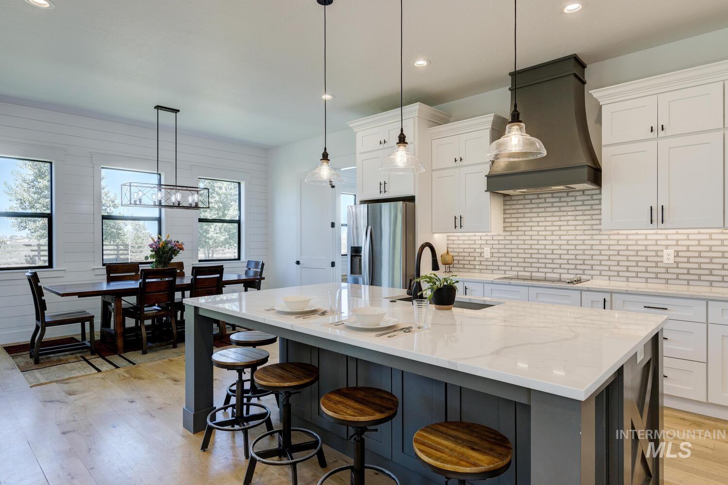 Kitchen featuring appliances with stainless steel finishes, custom range hood, light wood-style flooring, healthy amount of natural light, and recessed lighting