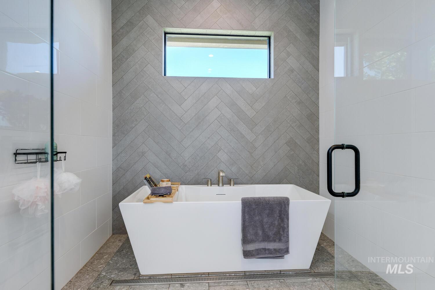 Full bathroom with a freestanding tub and tile walls