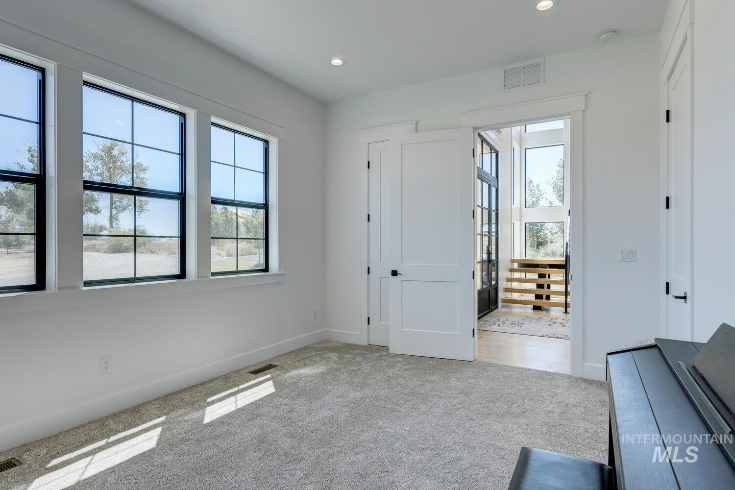 Unfurnished bedroom with light carpet and recessed lighting