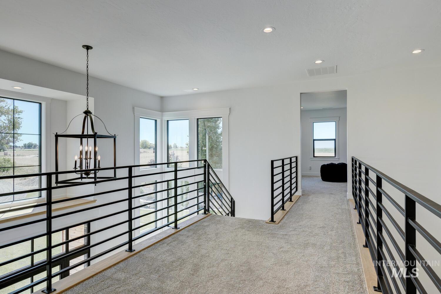 Hall with a chandelier, an upstairs landing, carpet, and recessed lighting