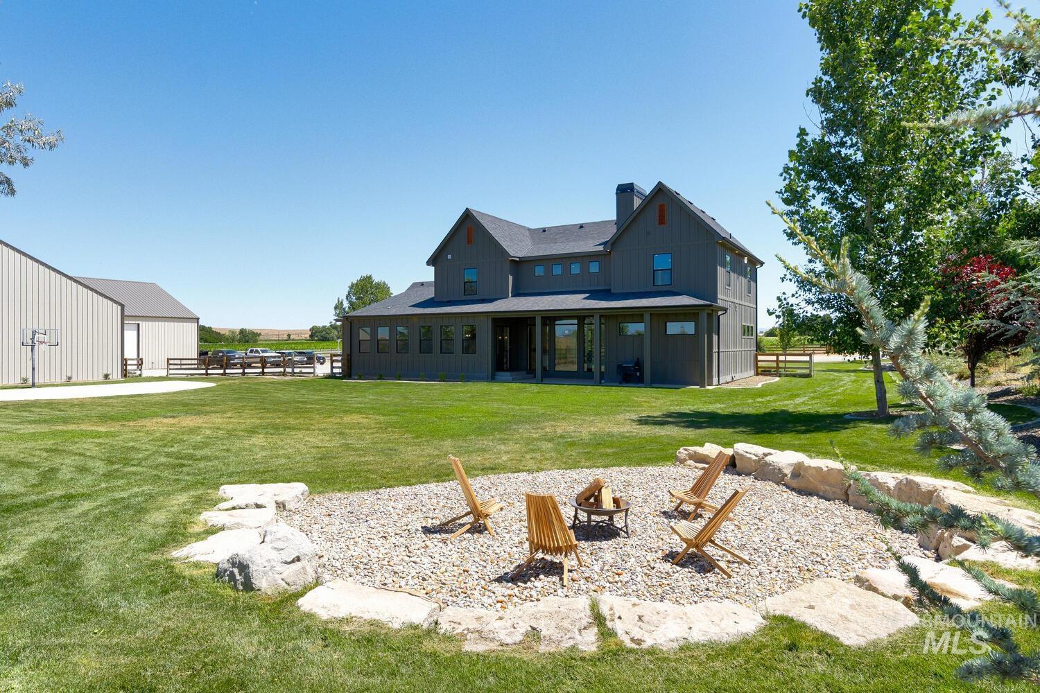 Rear view of property with an outdoor fire pit, a chimney, and board and batten siding