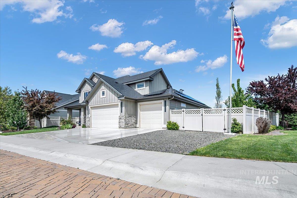 Modern home exterior featuring gray siding, stone accents, and a dark shingle roof