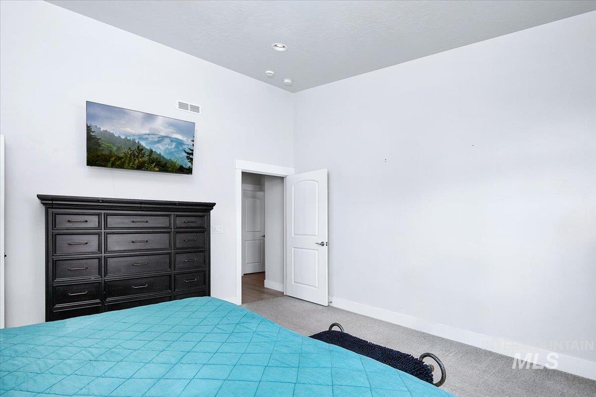 Room featuring light gray walls, recessed ceiling lighting, baseboard trim, and gray carpet flooring