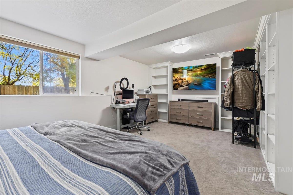 Bedroom featuring light colored carpet and an office area