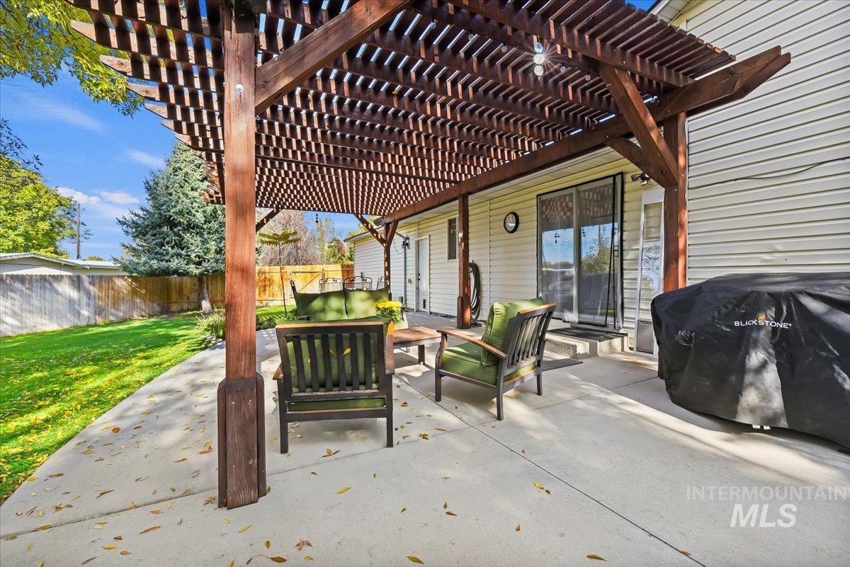 Fenced backyard featuring a patio area, area for grilling, a pergola, and outdoor lounge area