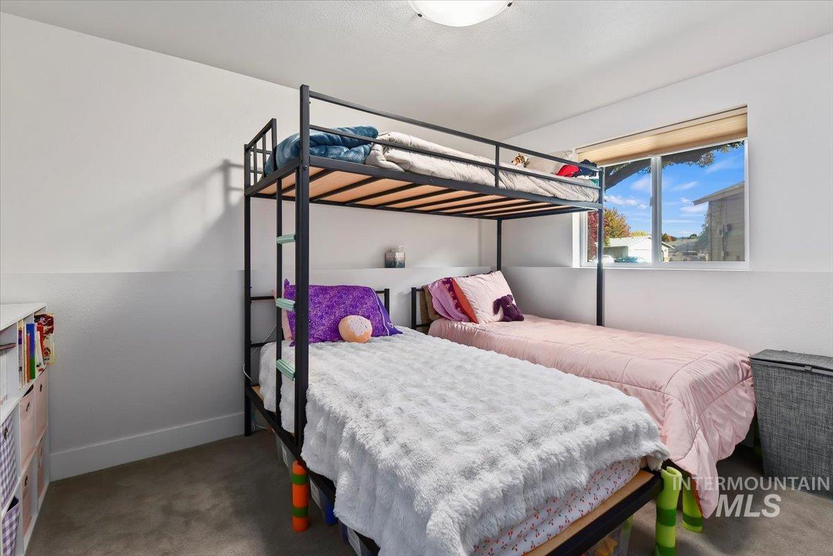 Bedroom featuring baseboards and dark colored carpet