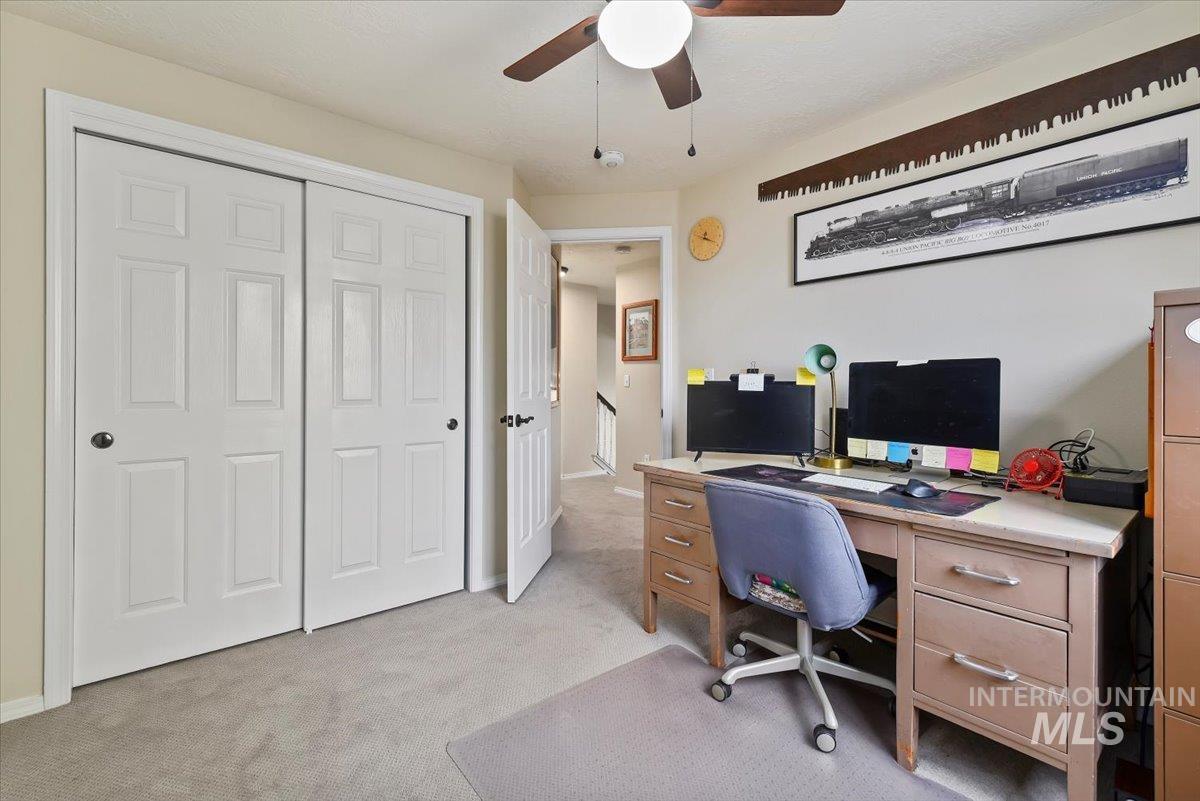 Home office featuring light carpet and ceiling fan