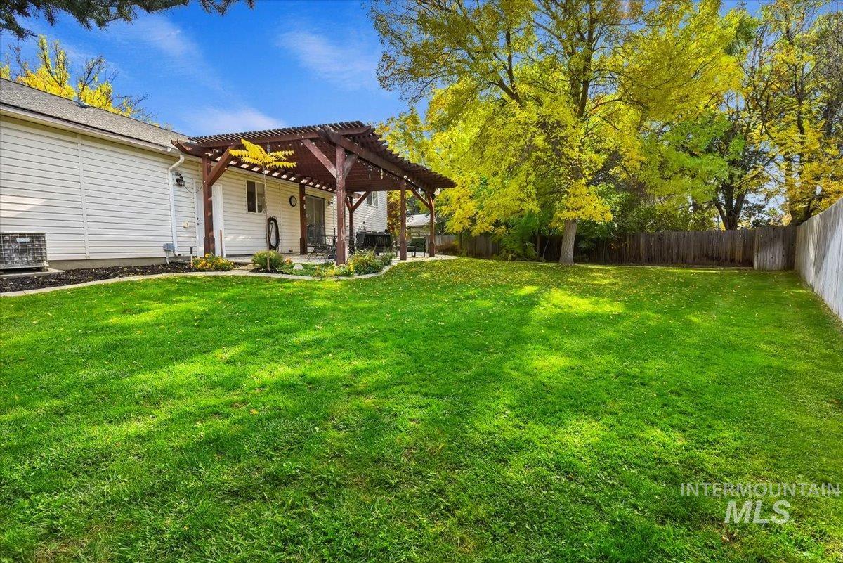 Fenced backyard with a pergola and a patio