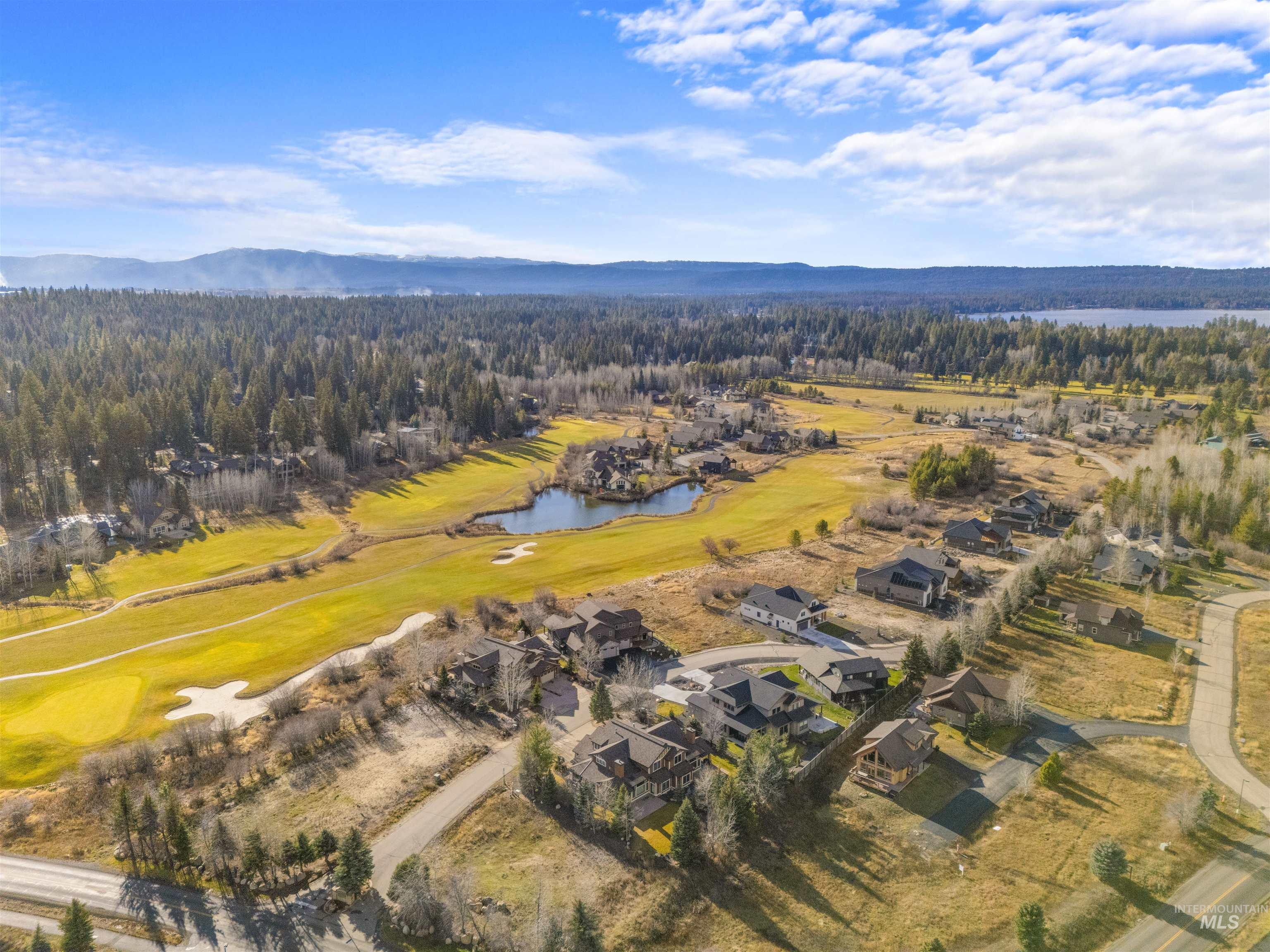 Aerial view of property and surrounding area featuring a water and mountain view and nearby suburban area