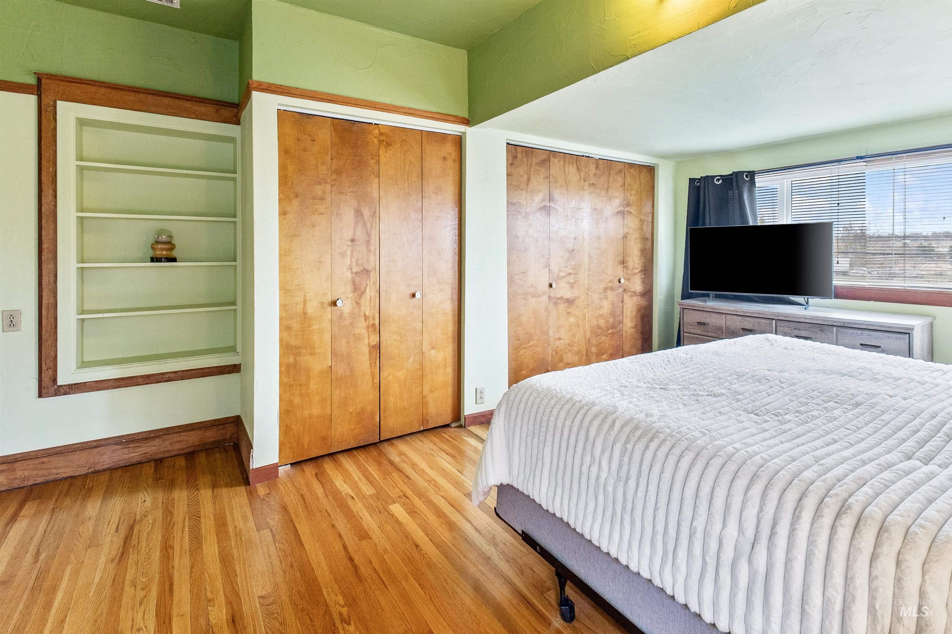 Bedroom featuring multiple closets and wood finished floors