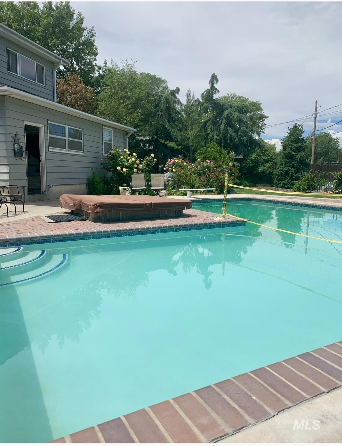 Swimming pool with a patio area and a hot tub