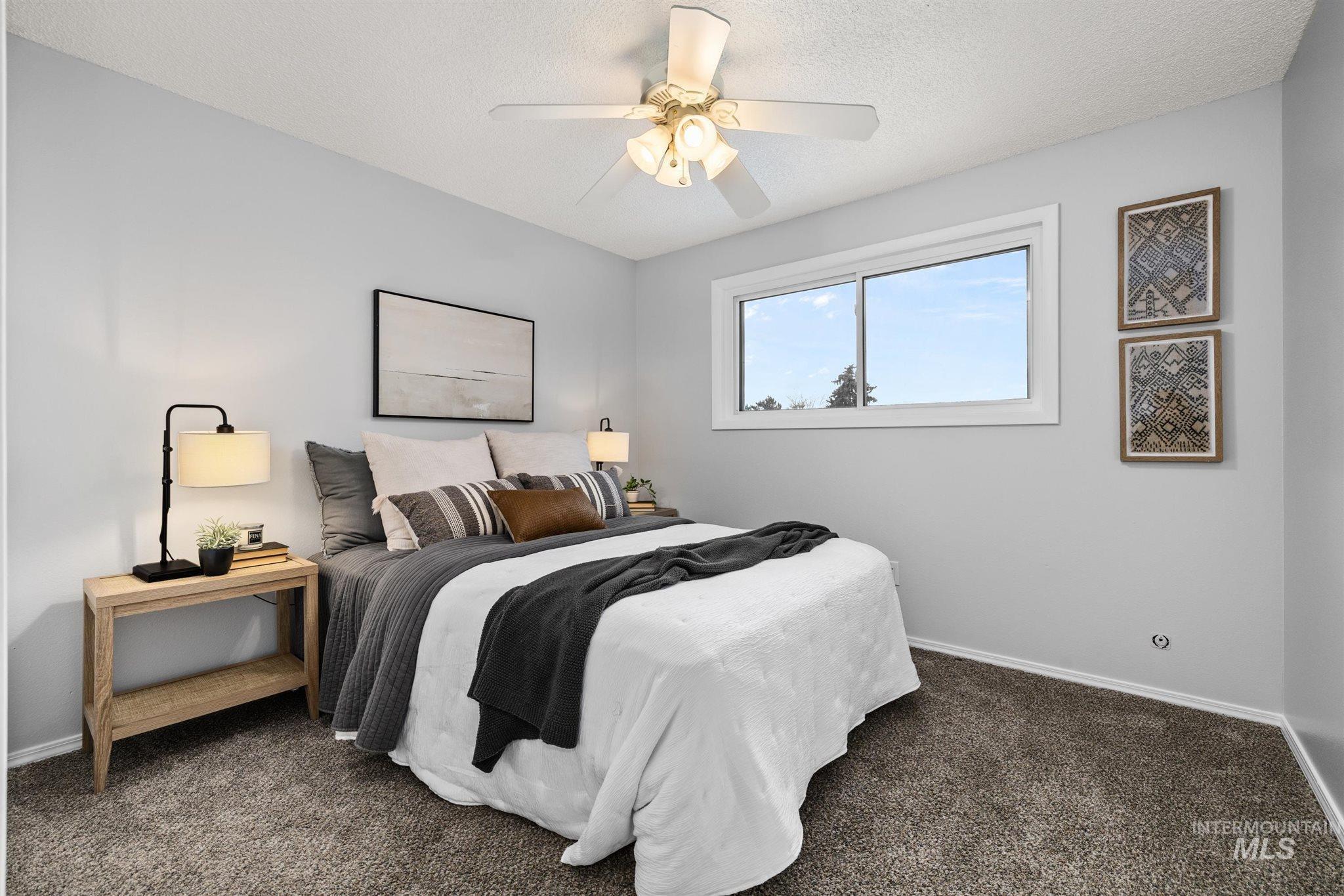 Bedroom featuring dark carpet, a ceiling fan, and a textured ceiling