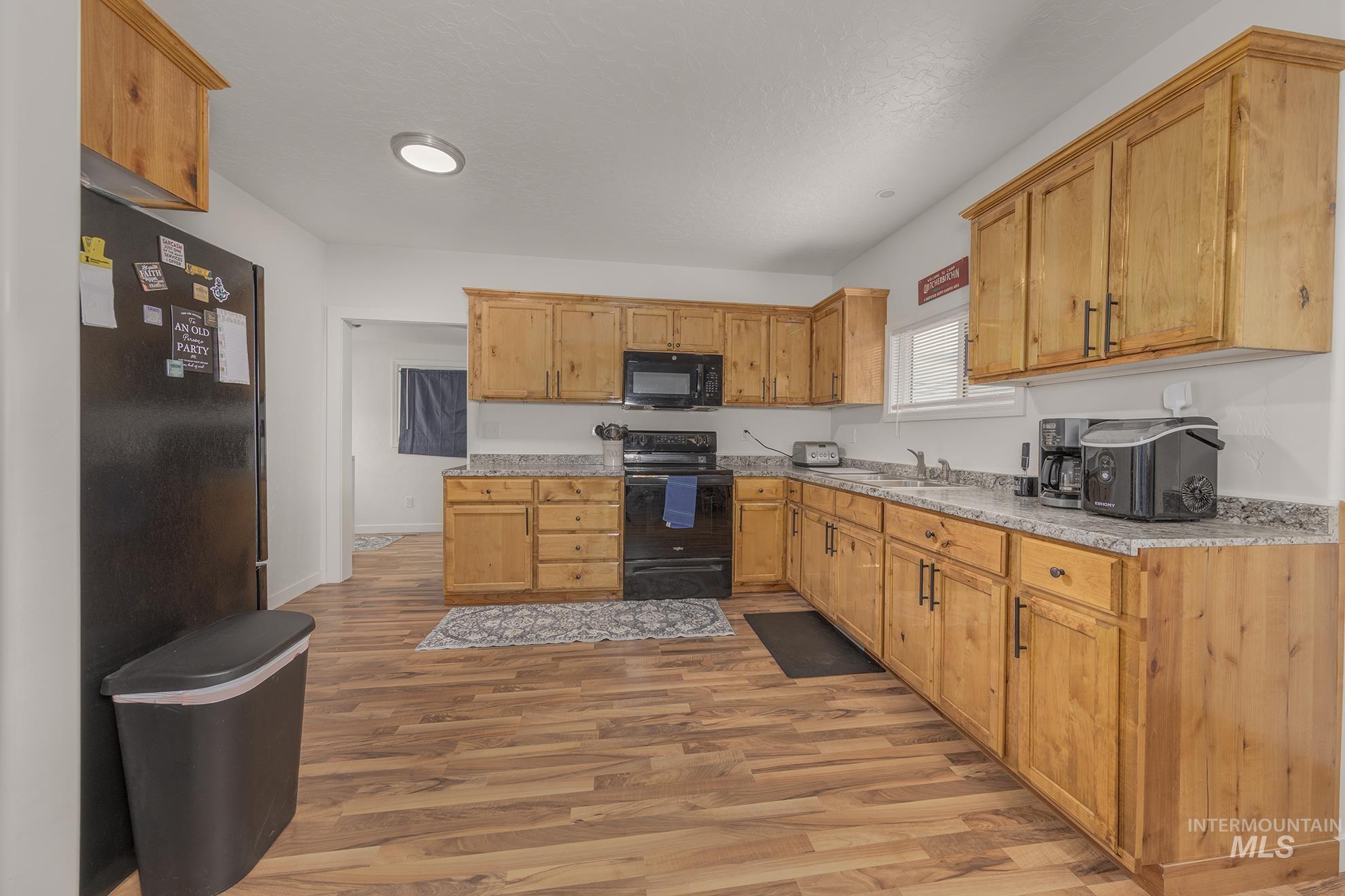 Kitchen featuring black appliances and light wood-type flooring