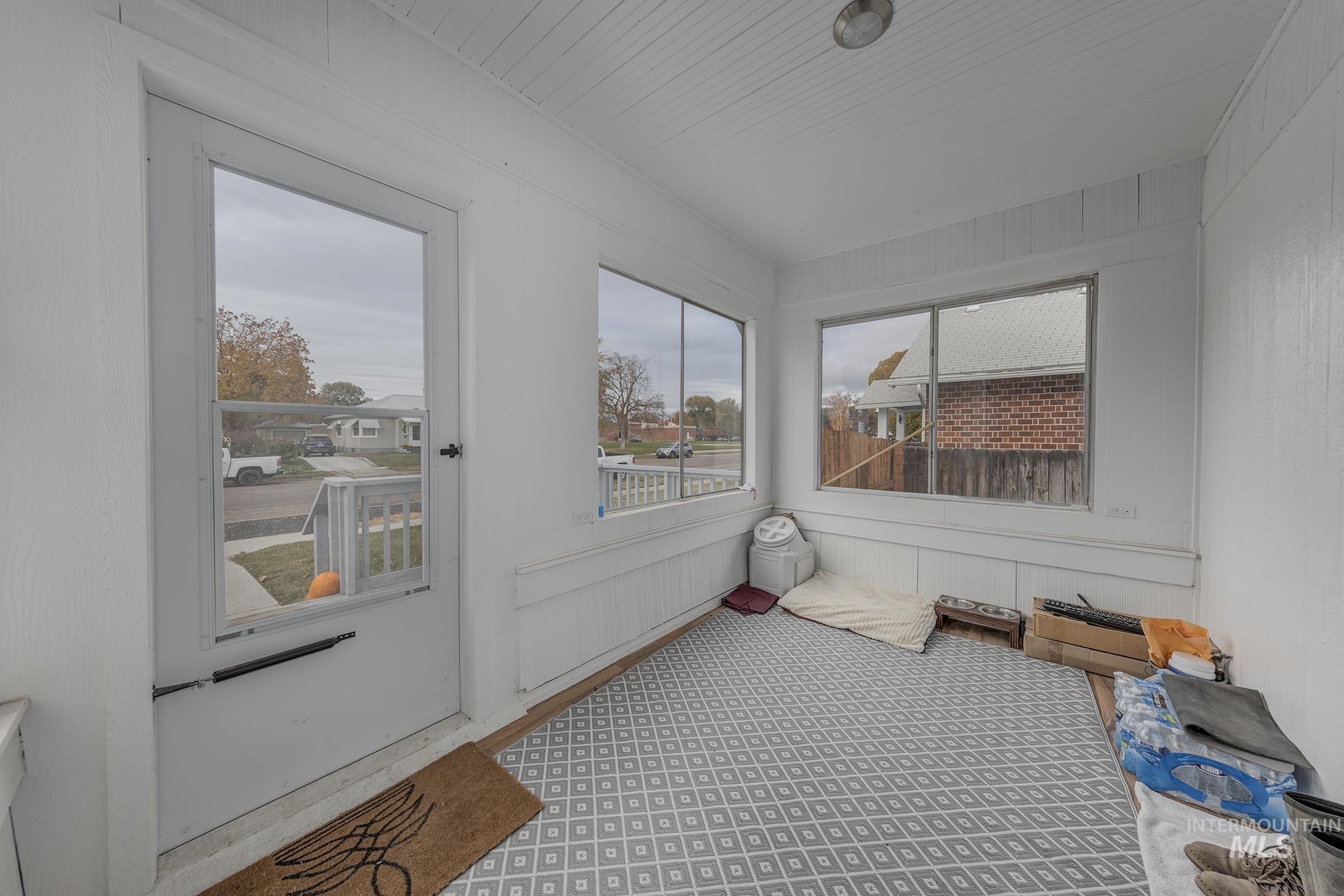 Sunroom featuring wood walls and carpet floors
