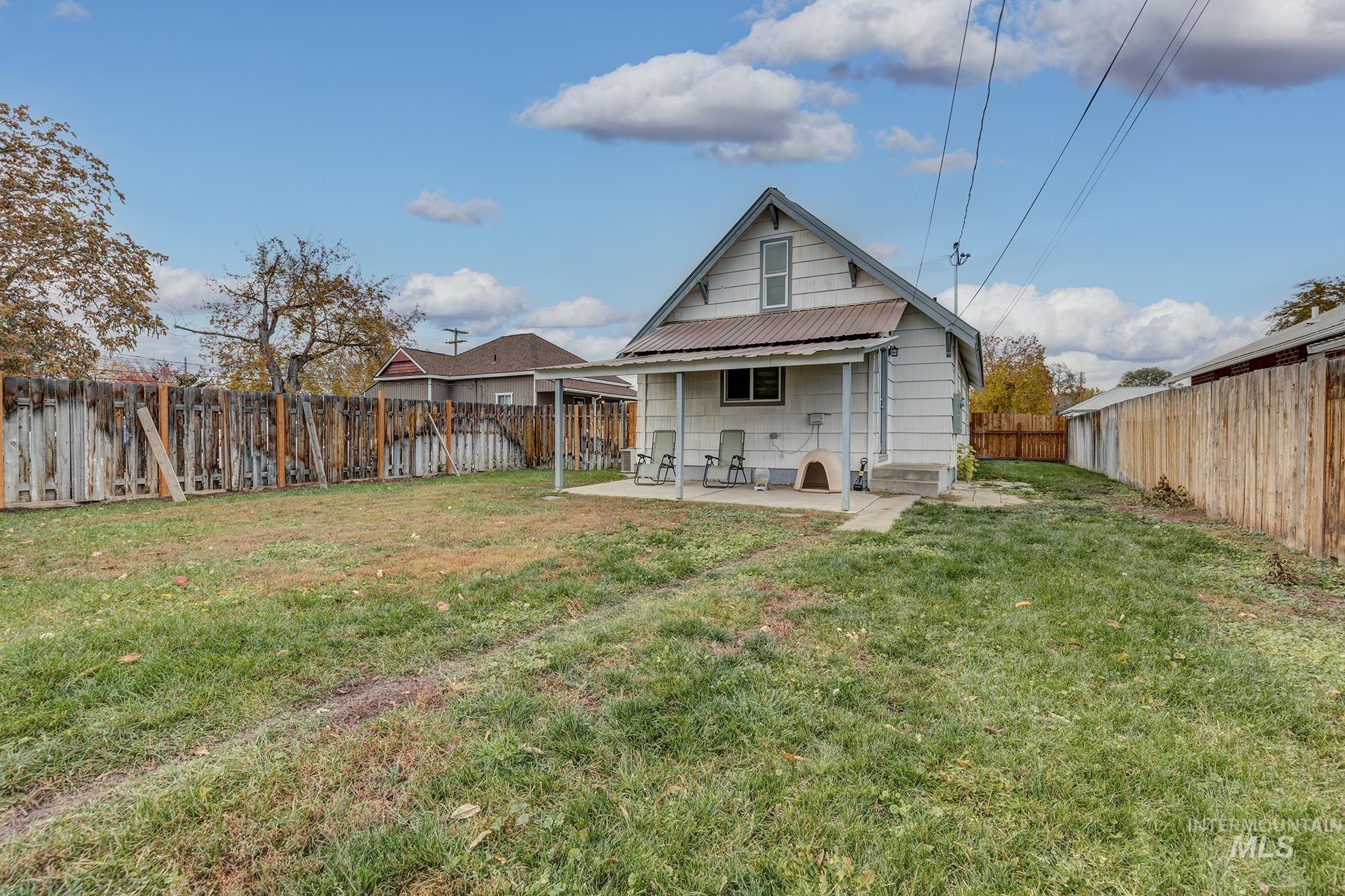 Back of property with a patio, a fenced backyard, and a metal roof