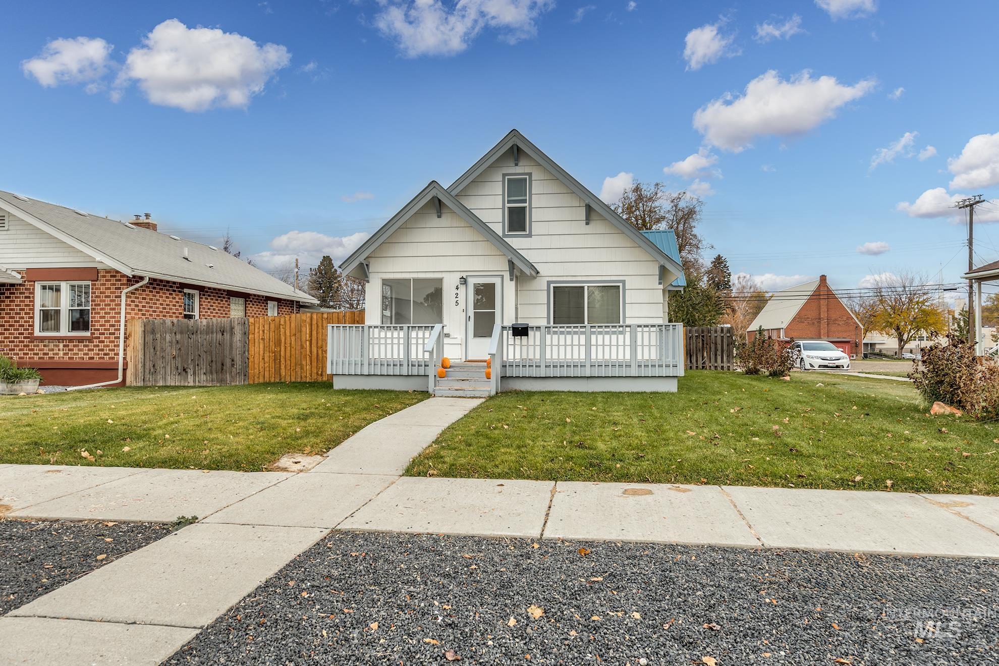 Bungalow-style home with a wooden deck and brick siding