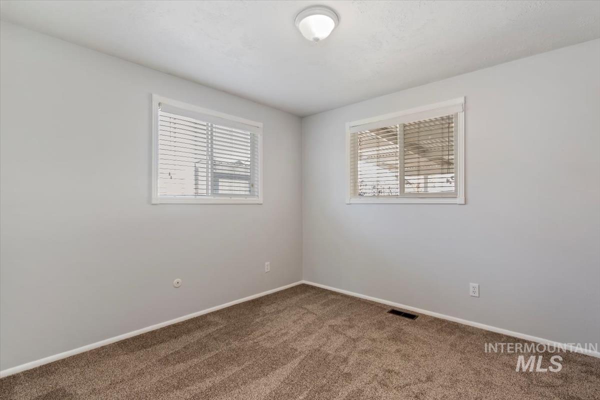 Carpeted spare room with baseboards