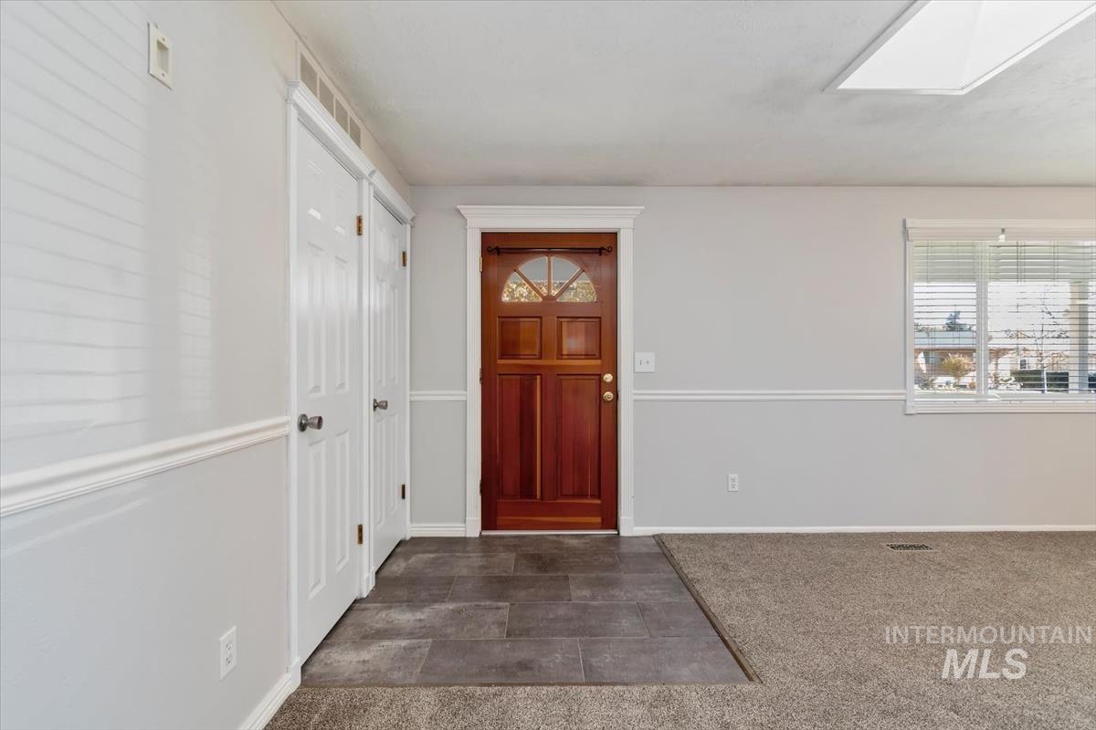 Entrance foyer featuring dark colored carpet and a skylight