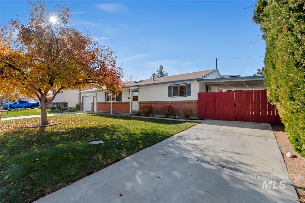 Single story home featuring brick siding, driveway, and a gate
