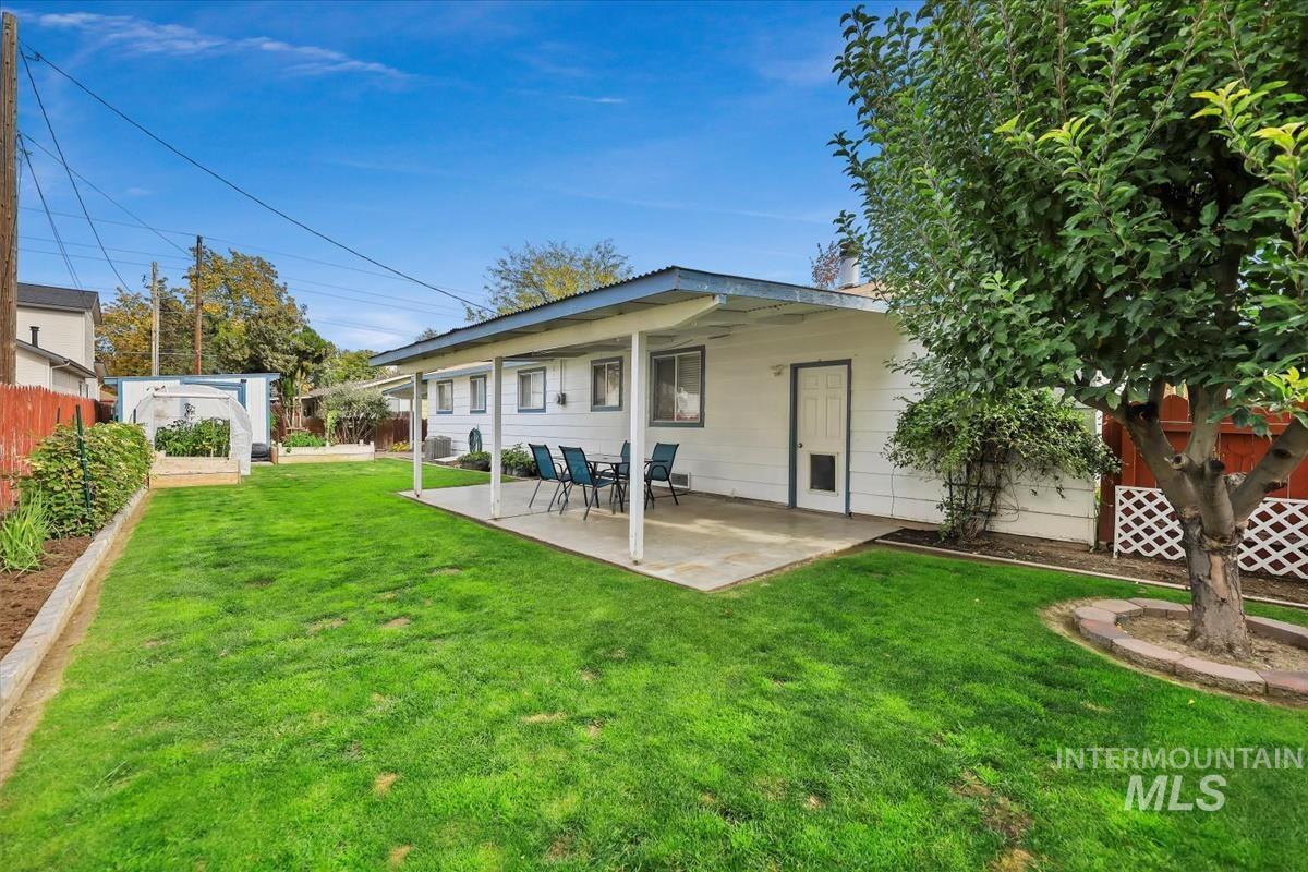 Back of house with a fenced backyard, a patio, and an outbuilding