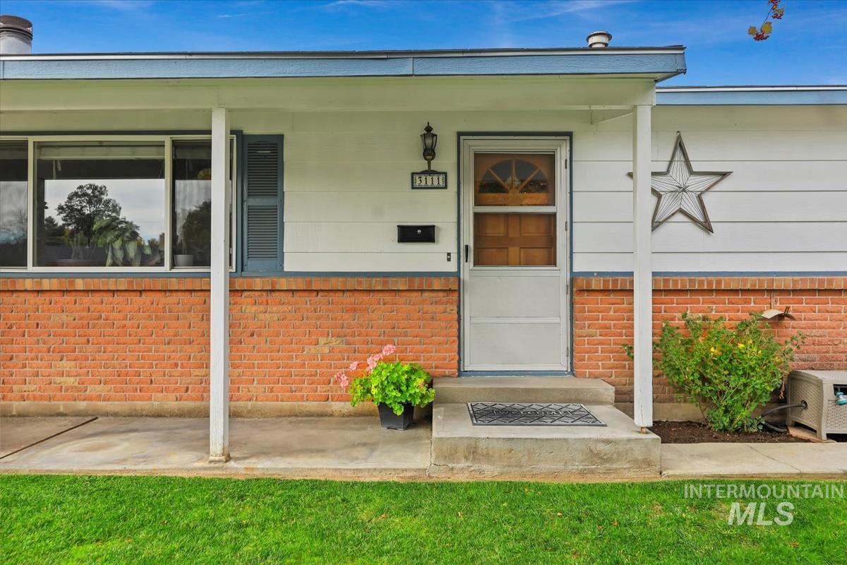 Doorway to property with brick siding and a porch